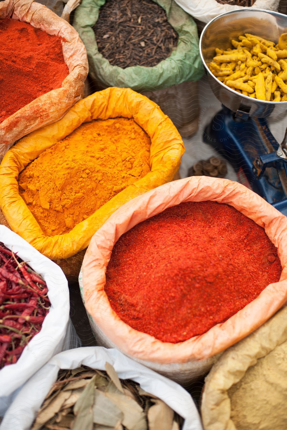 Red pink yellow and white curry spices with other ingredients on a table