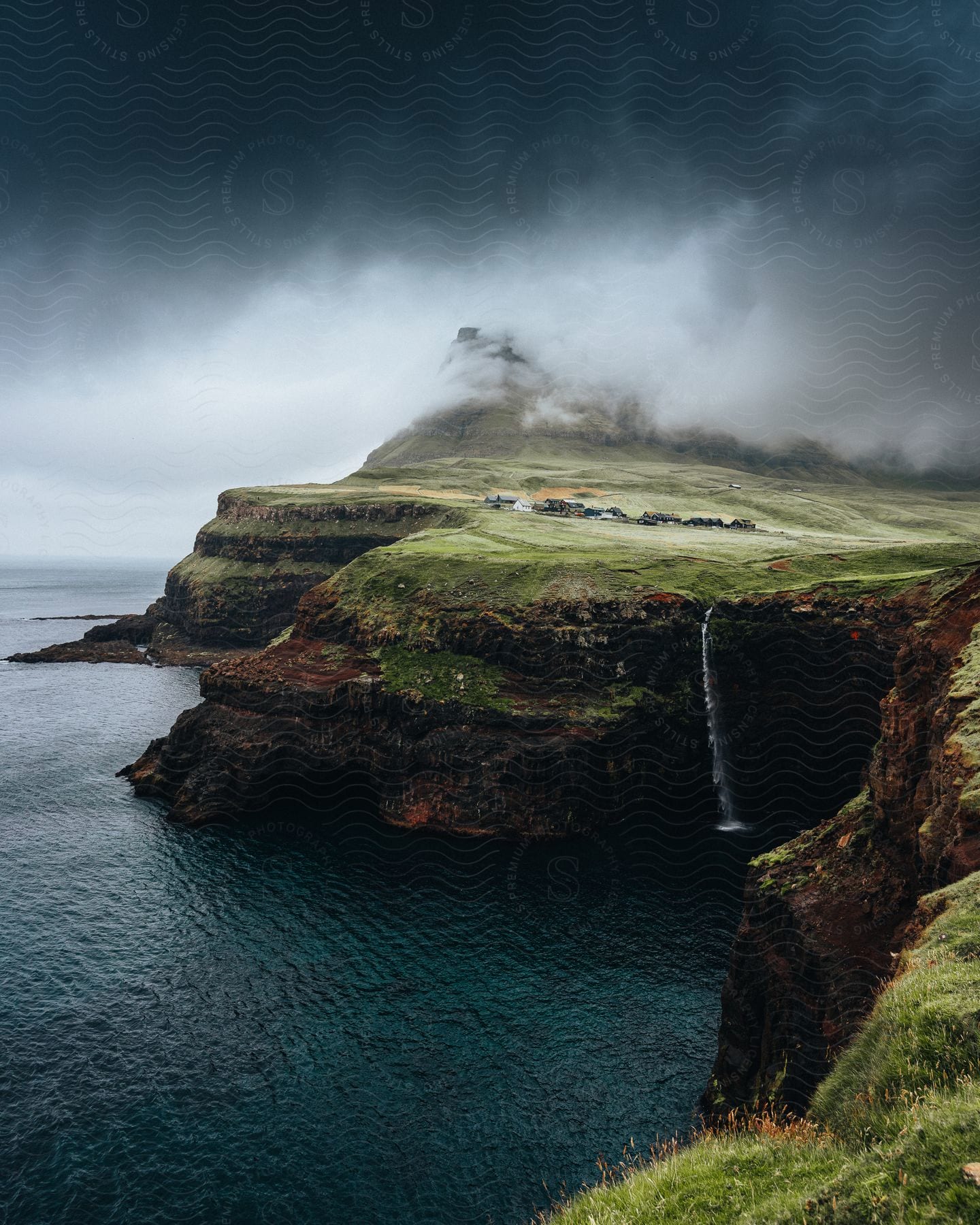 A vast land surrounded by towering rock formations in the faroe islands