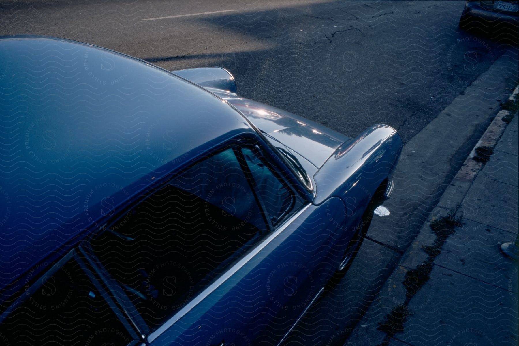 A parked blue car on the curb