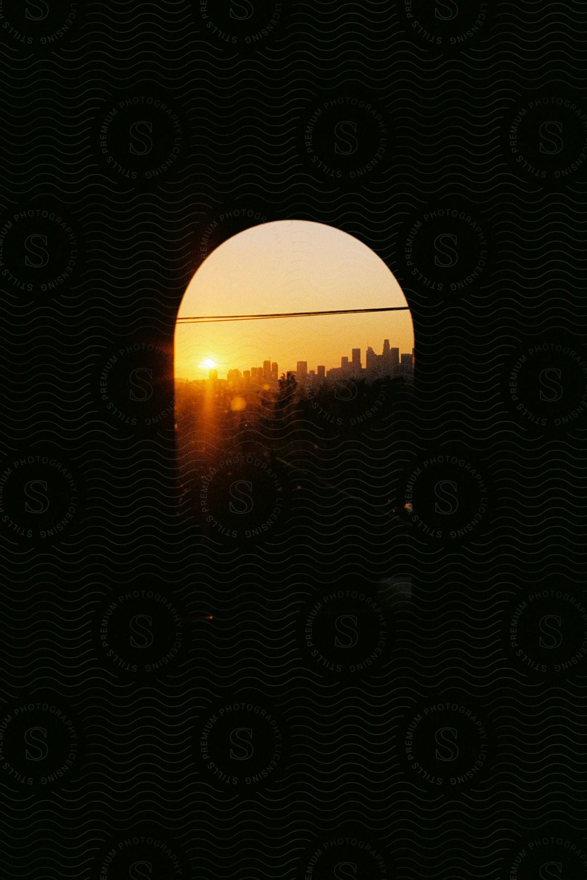 A sunset skyline of a big city seen through a window in a dark room