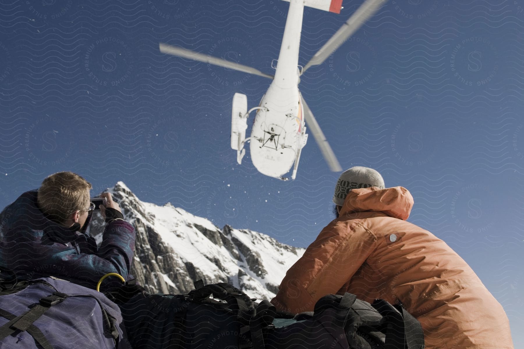 Two people looking at an airplane in the air