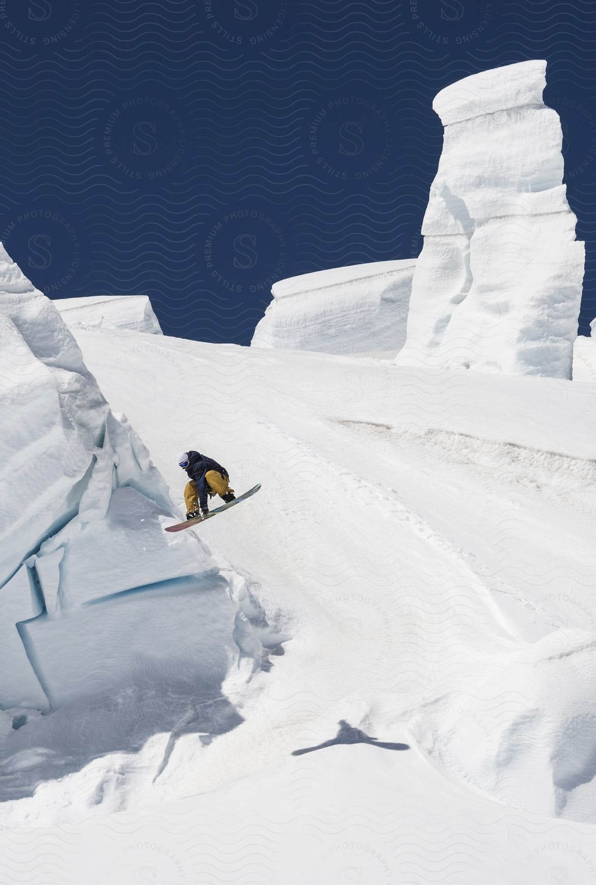 A snowboarder performs a jump above a mountain slope