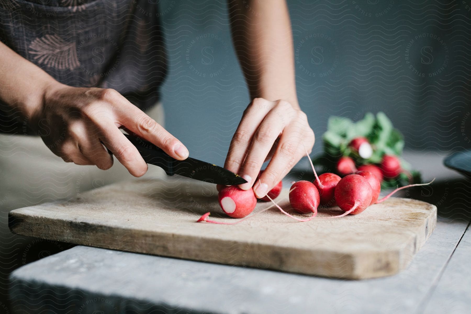 A chef slicing radishes on a cutting board
