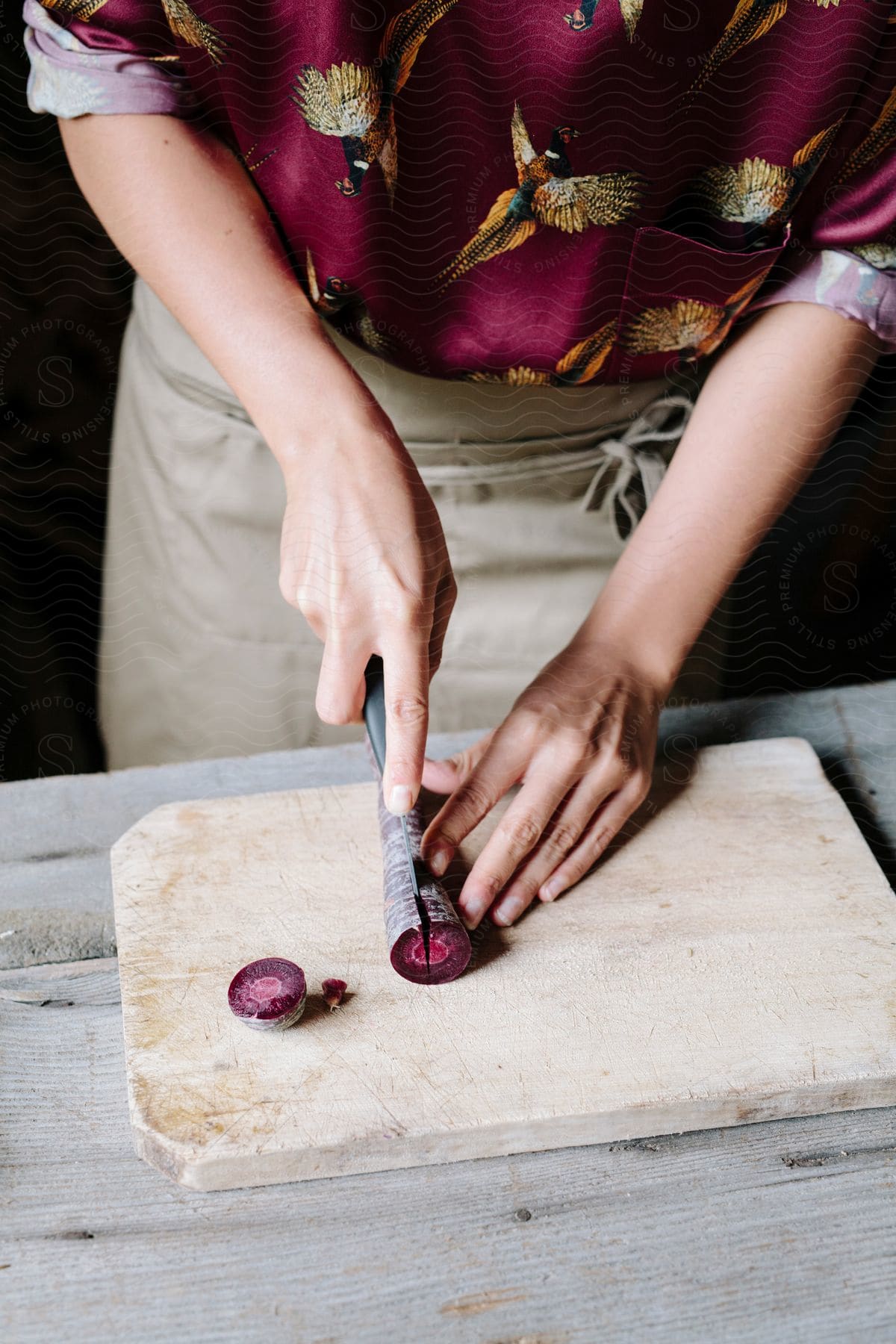 A chef slicing a purple carrot on a cutting board