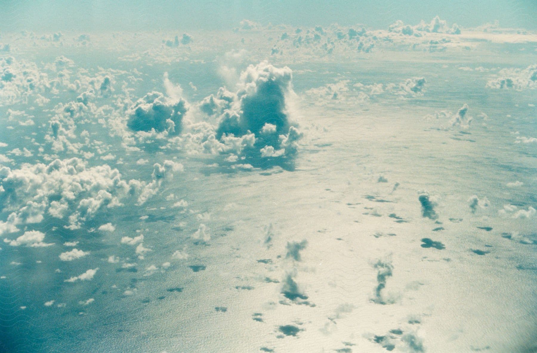 Clouds cast shadows onto sunlight reflecting water surface in an aerial view