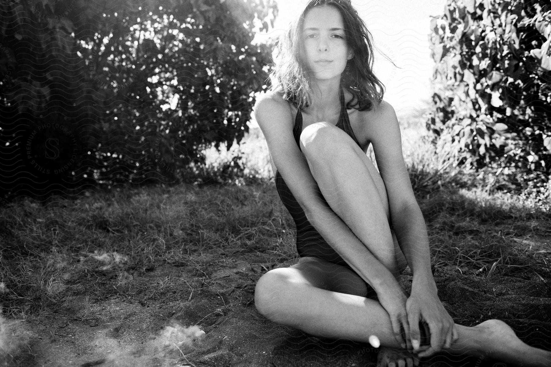 A lady seated on the ground in black and white