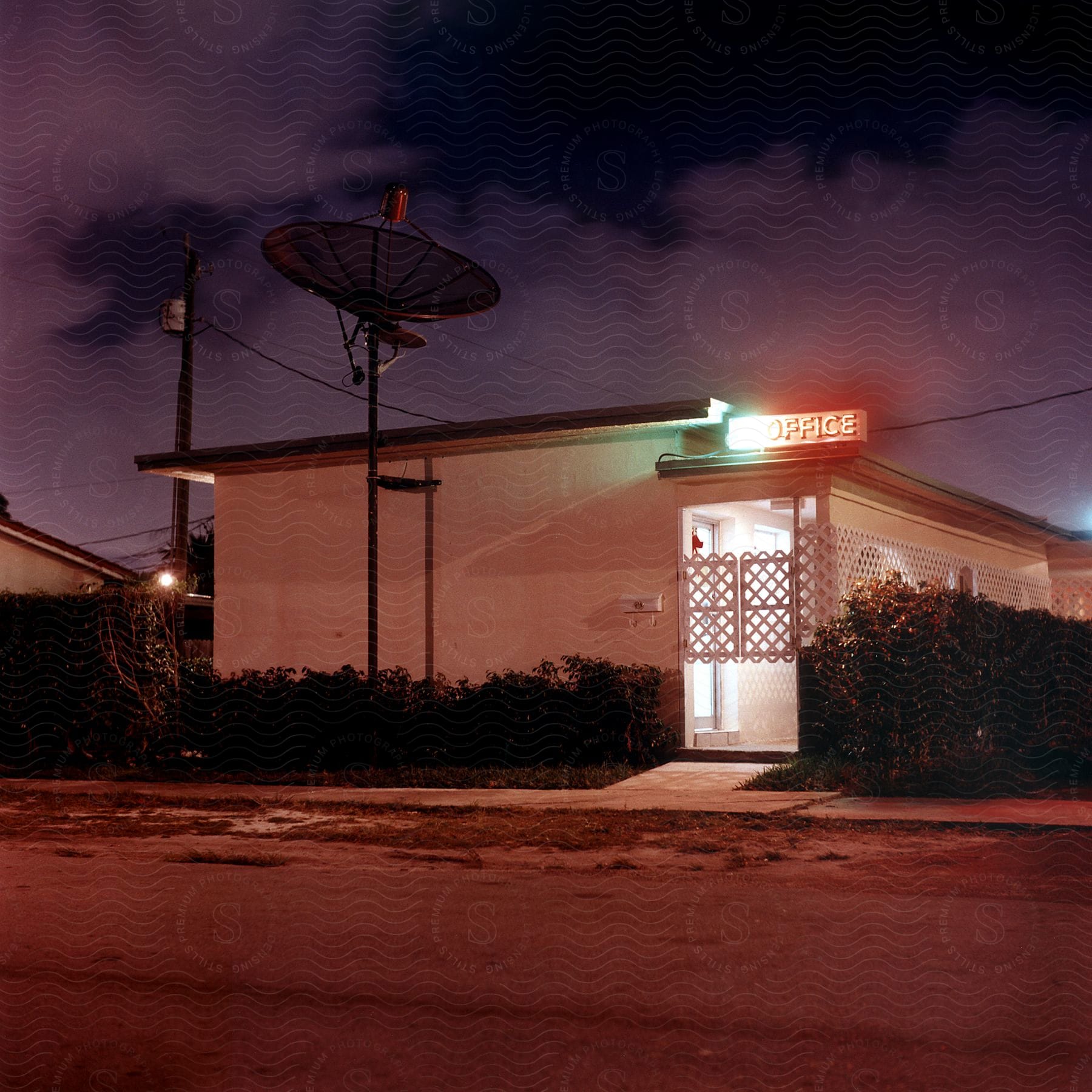 A motel office with a large satellite dish outside