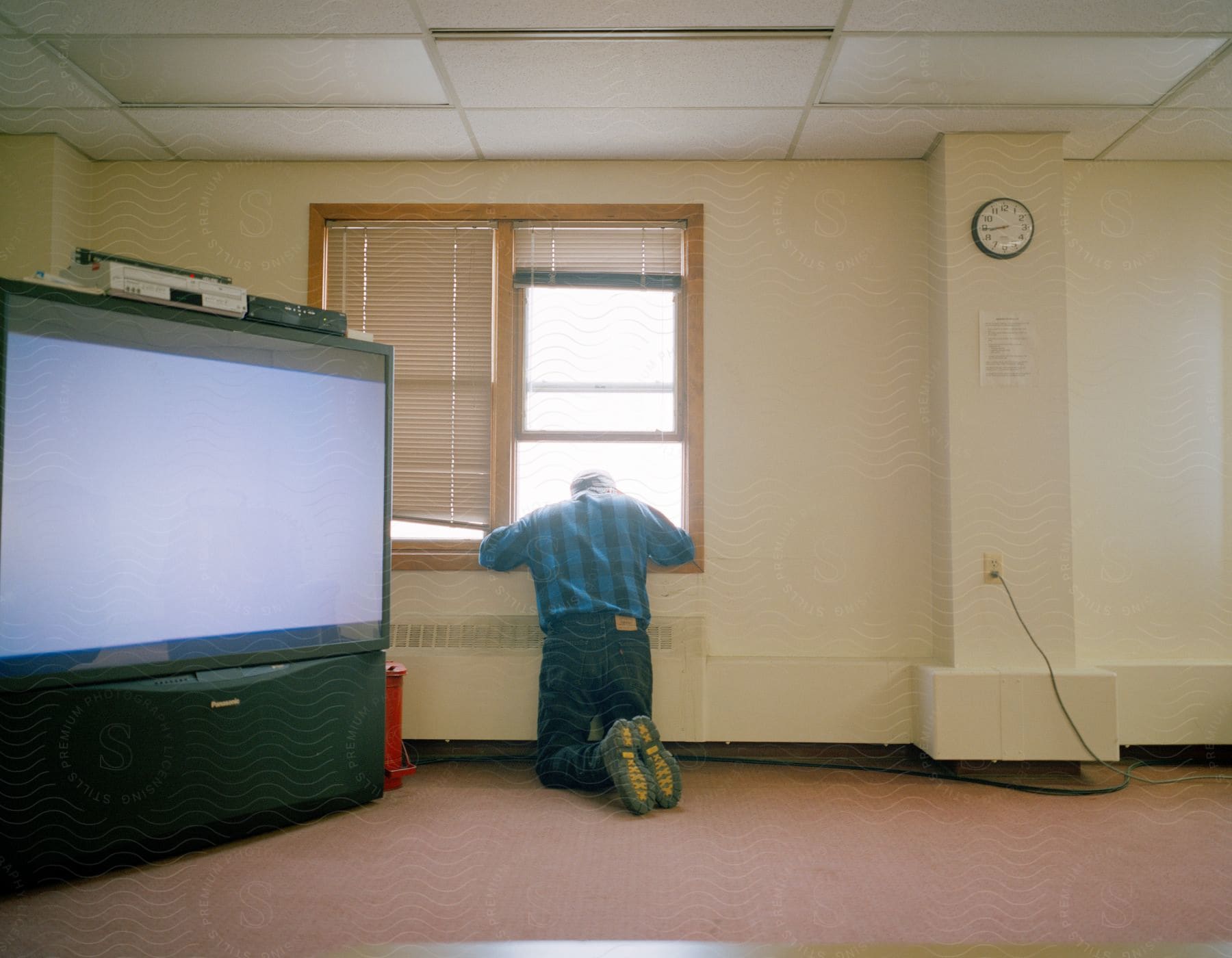 A man looking out a window in a spacious room