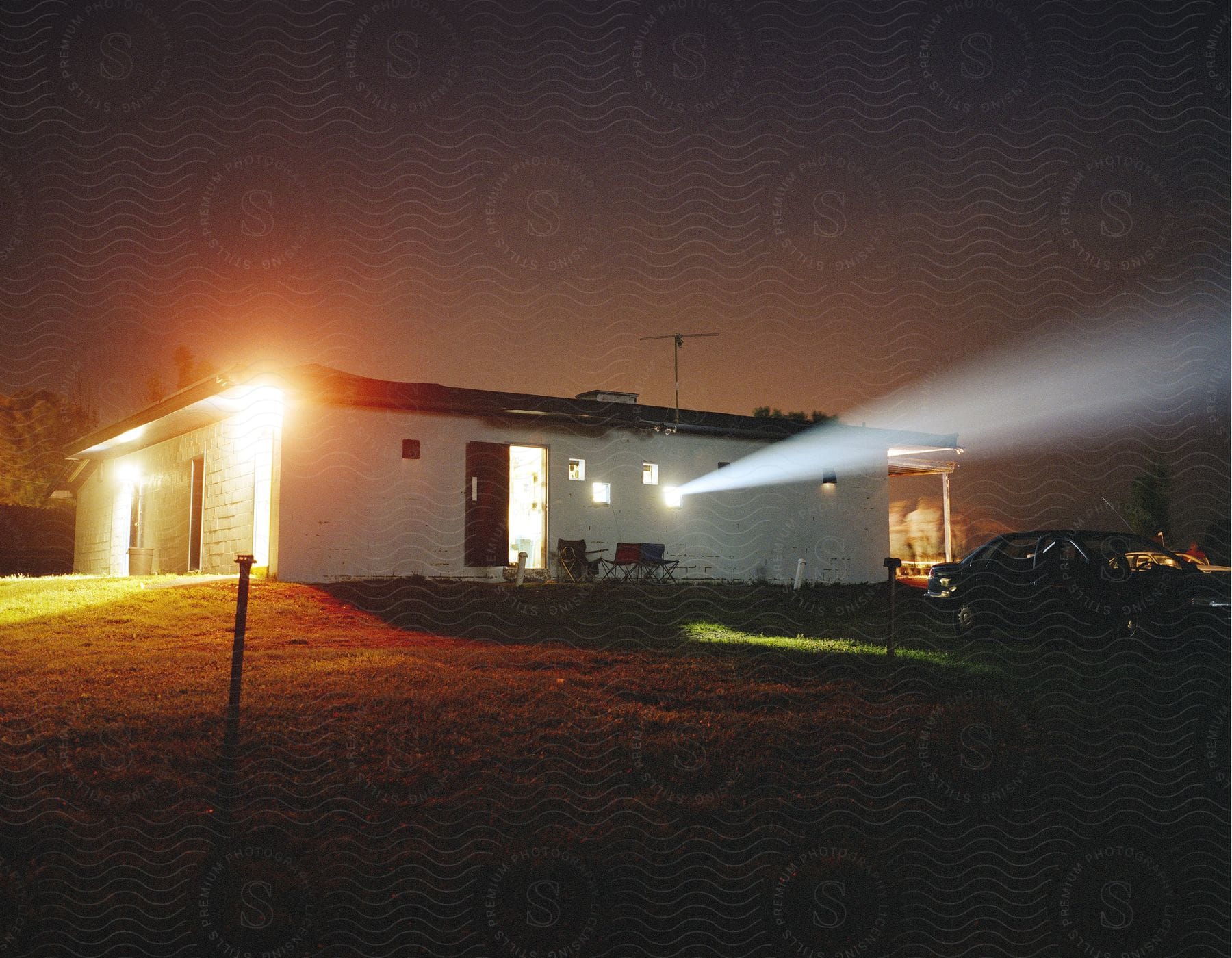 A one story house with a car parked out front in the evening in a suburban neighborhood in new york