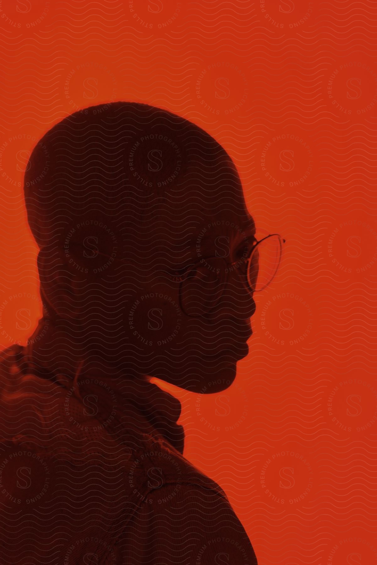 A contemplative adult woman in a room with a red background