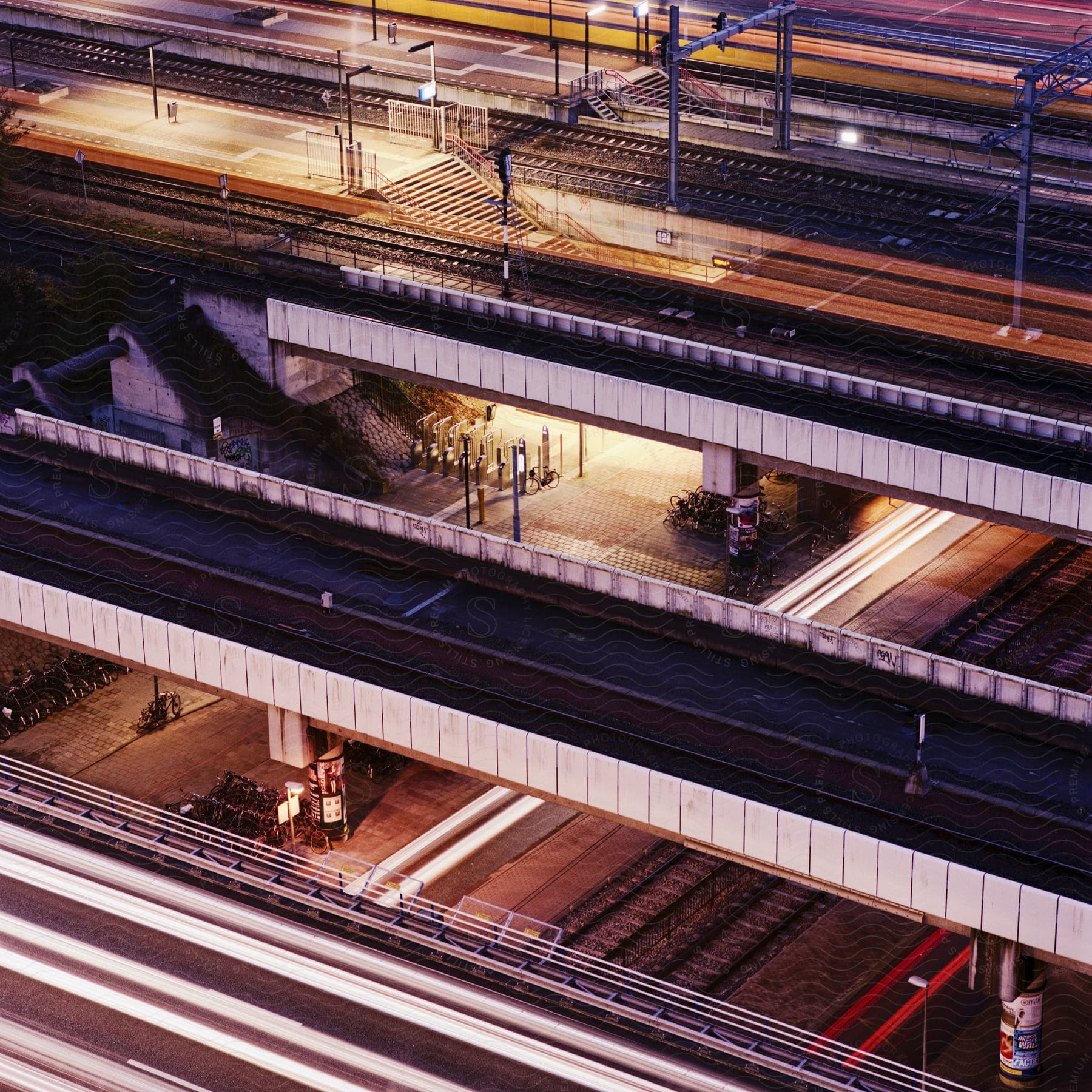 Night time view of three overpasses in a city for different modes of transportation such as a highway walkway and train tracks