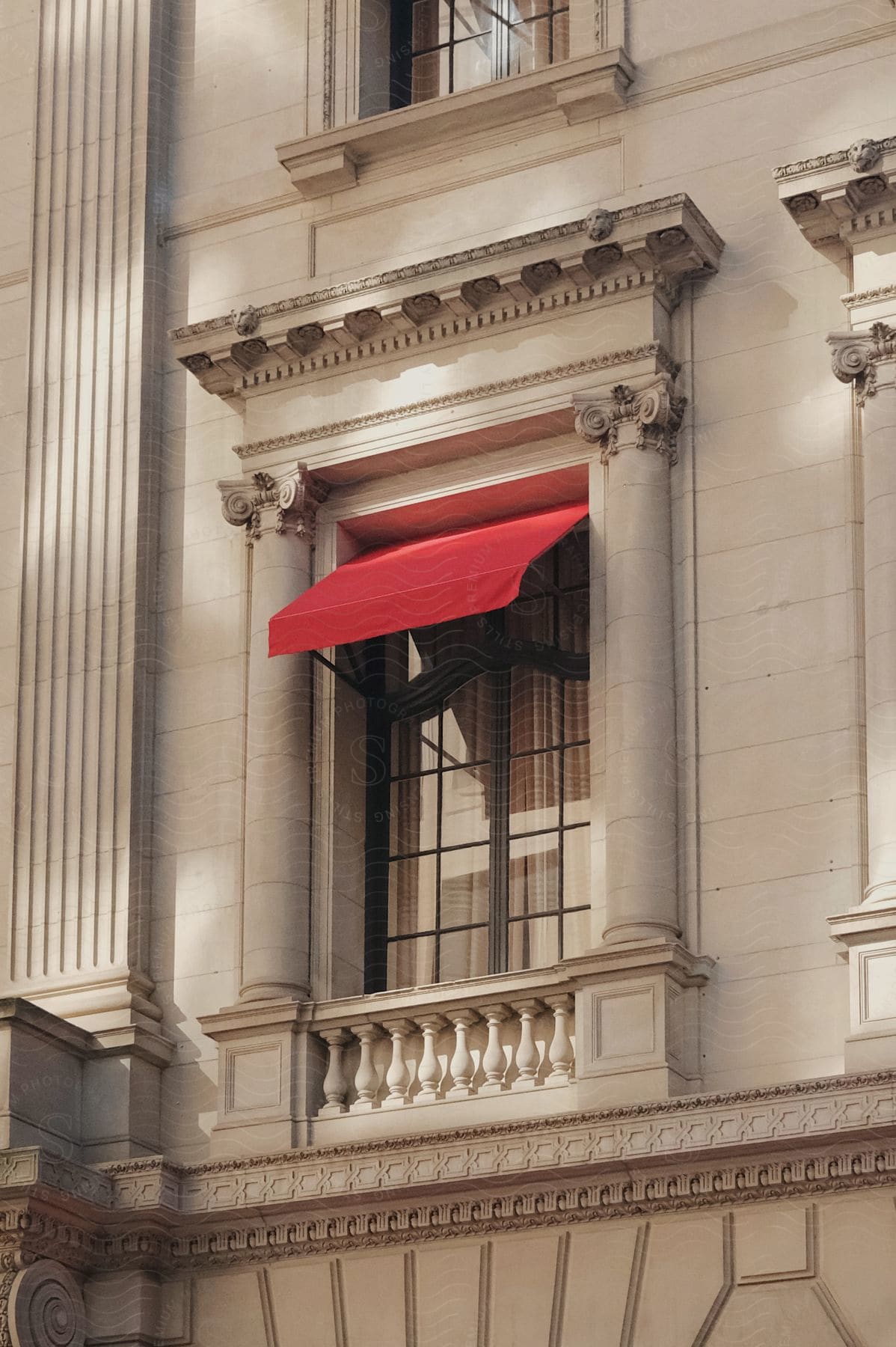 City building with architectural designs on walls and red awning over window