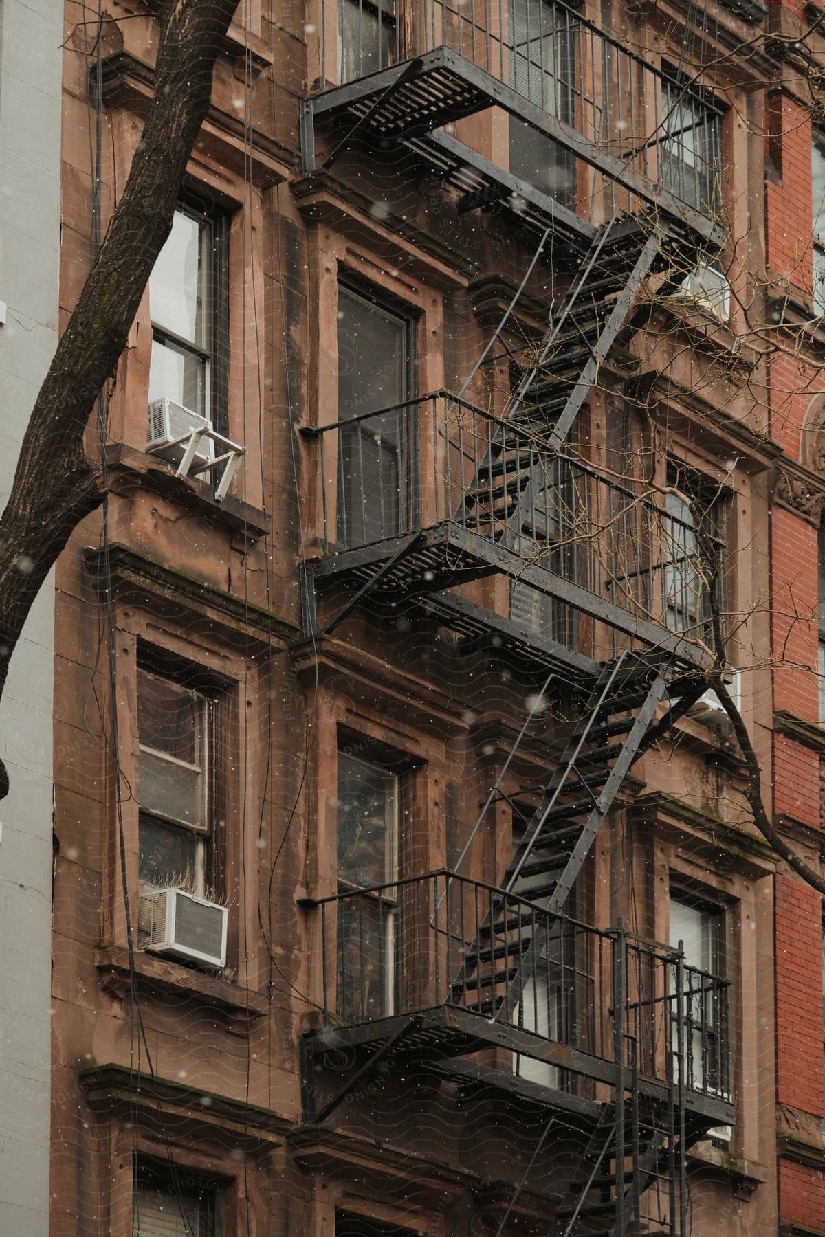 Wooden facade of a metropolitan apartment building with rectangular windows and fire escape