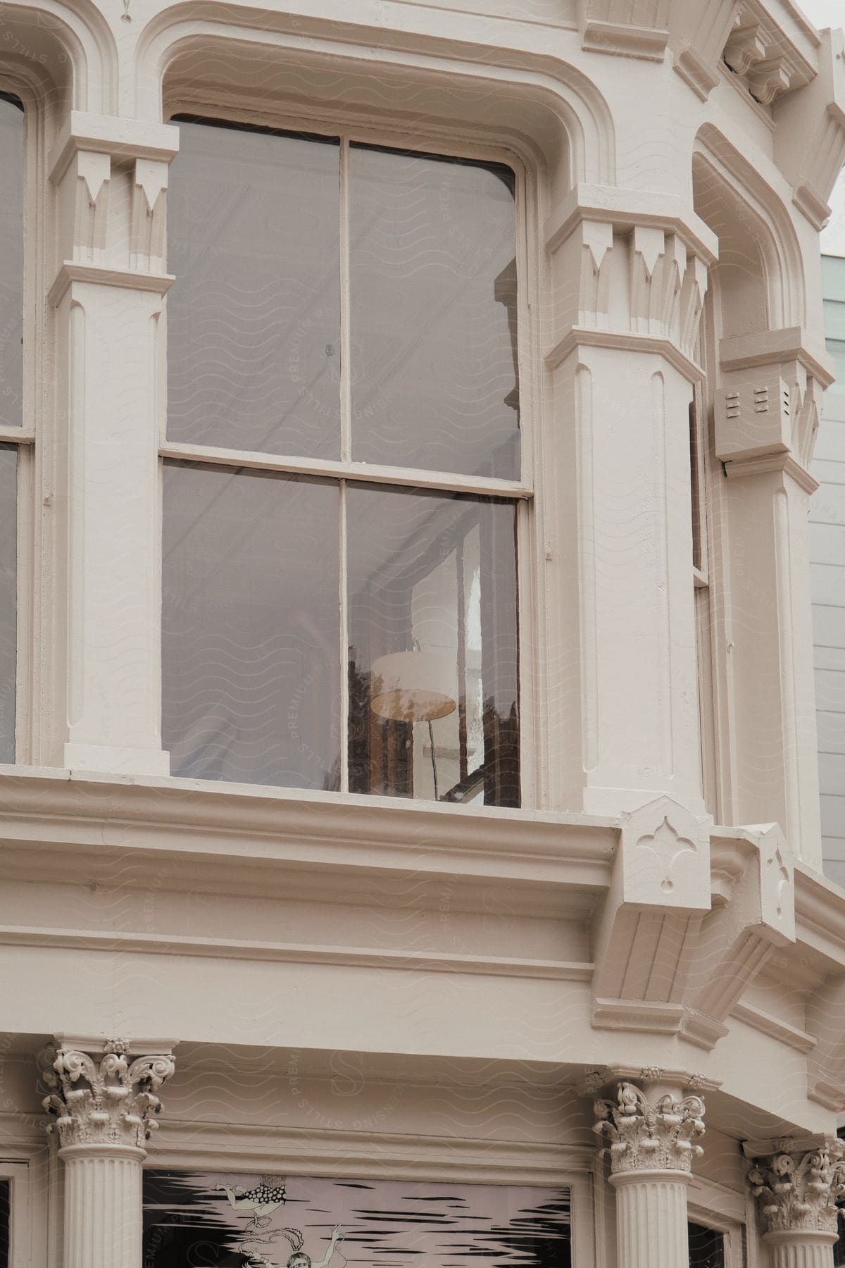 A white architectural building with sharpcornered columns and a large window pane