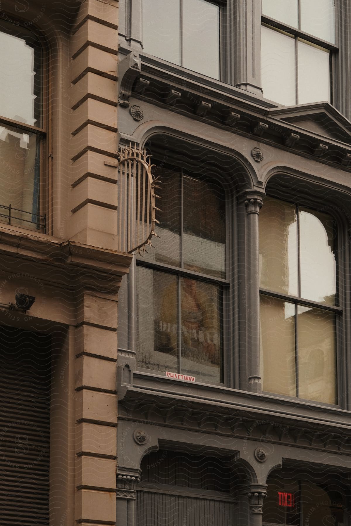 A framed piece of art is visible through a window in a city building