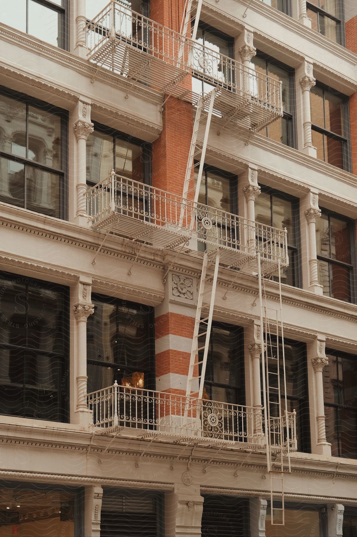 New york style apartment building with large rectangle windows and fire escapes