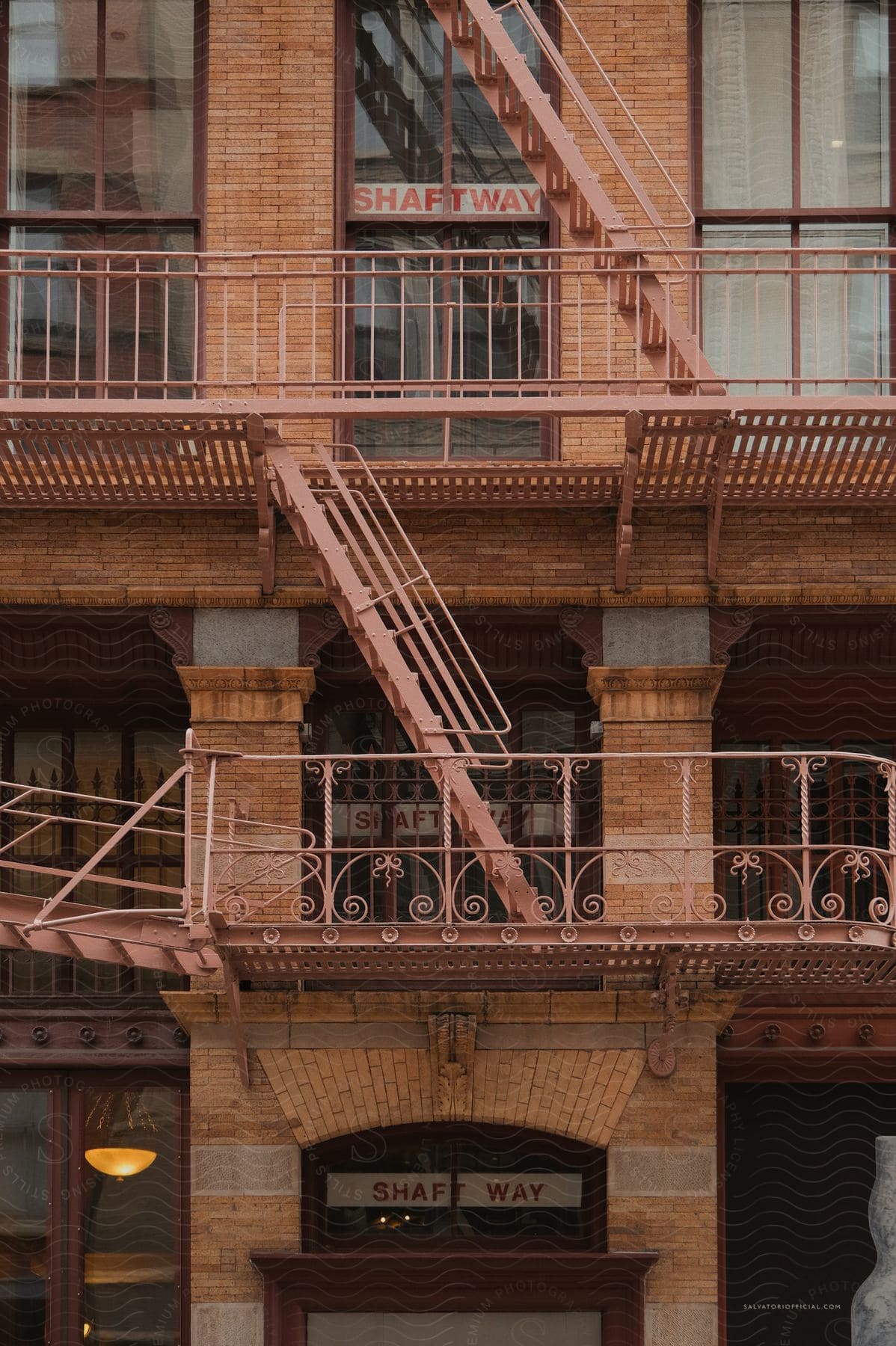 A neutral urban building with a staircase and handrail