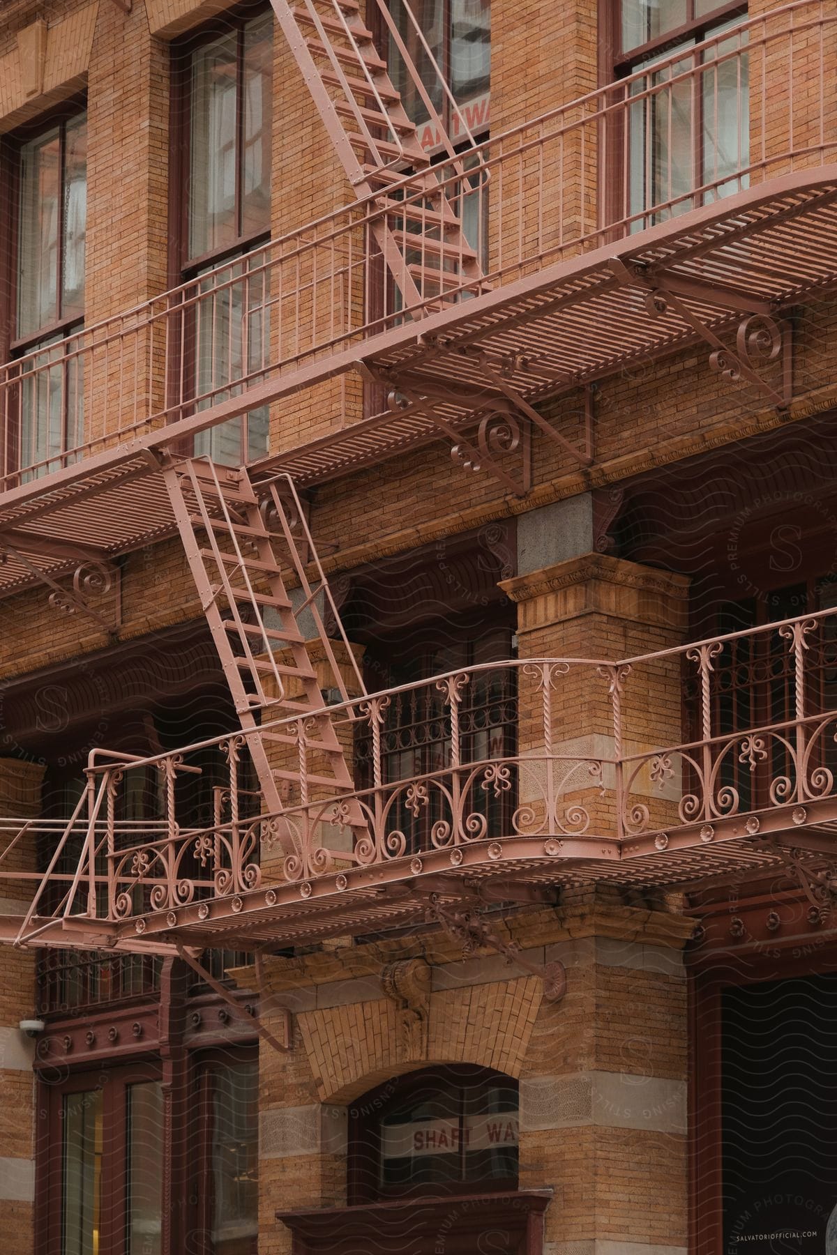 An old style brick building wall with a matching fire escape staircase