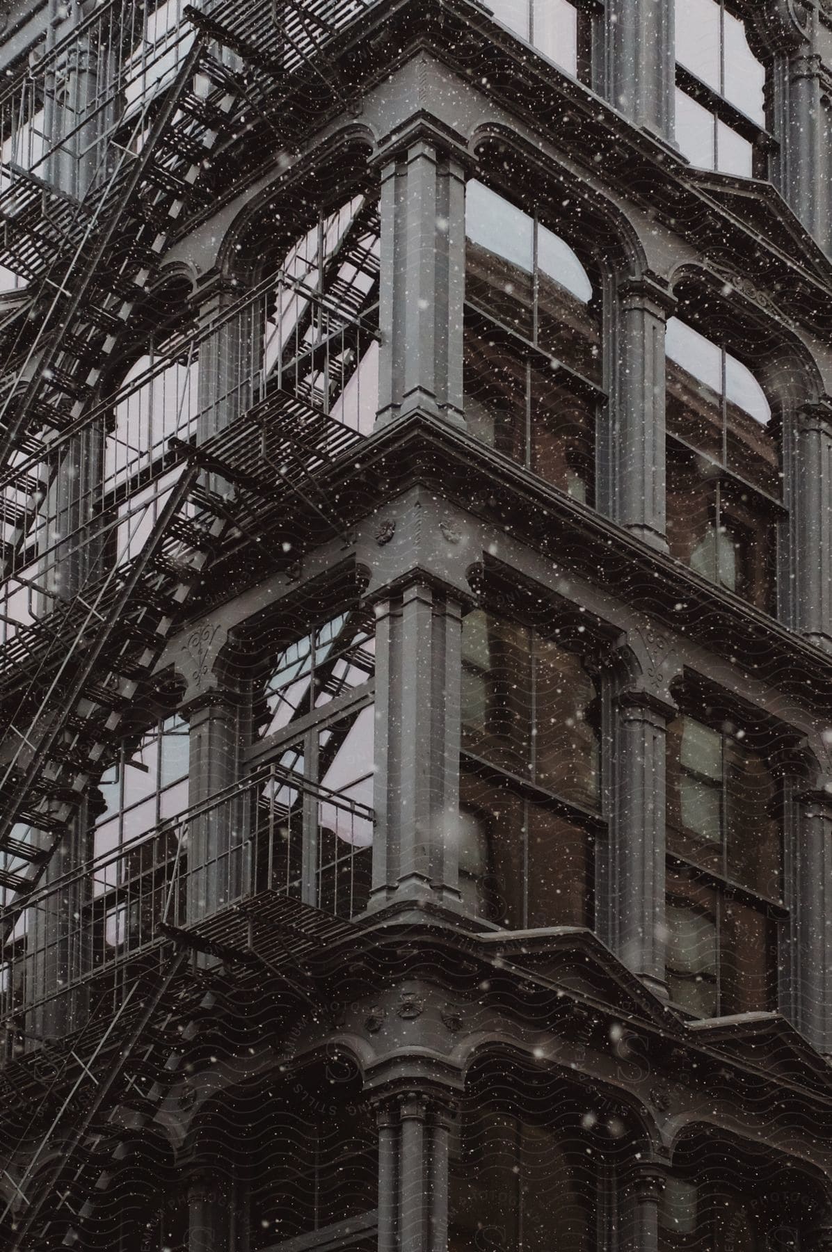 An old style corner building with a fire escape stairway on one of the sides