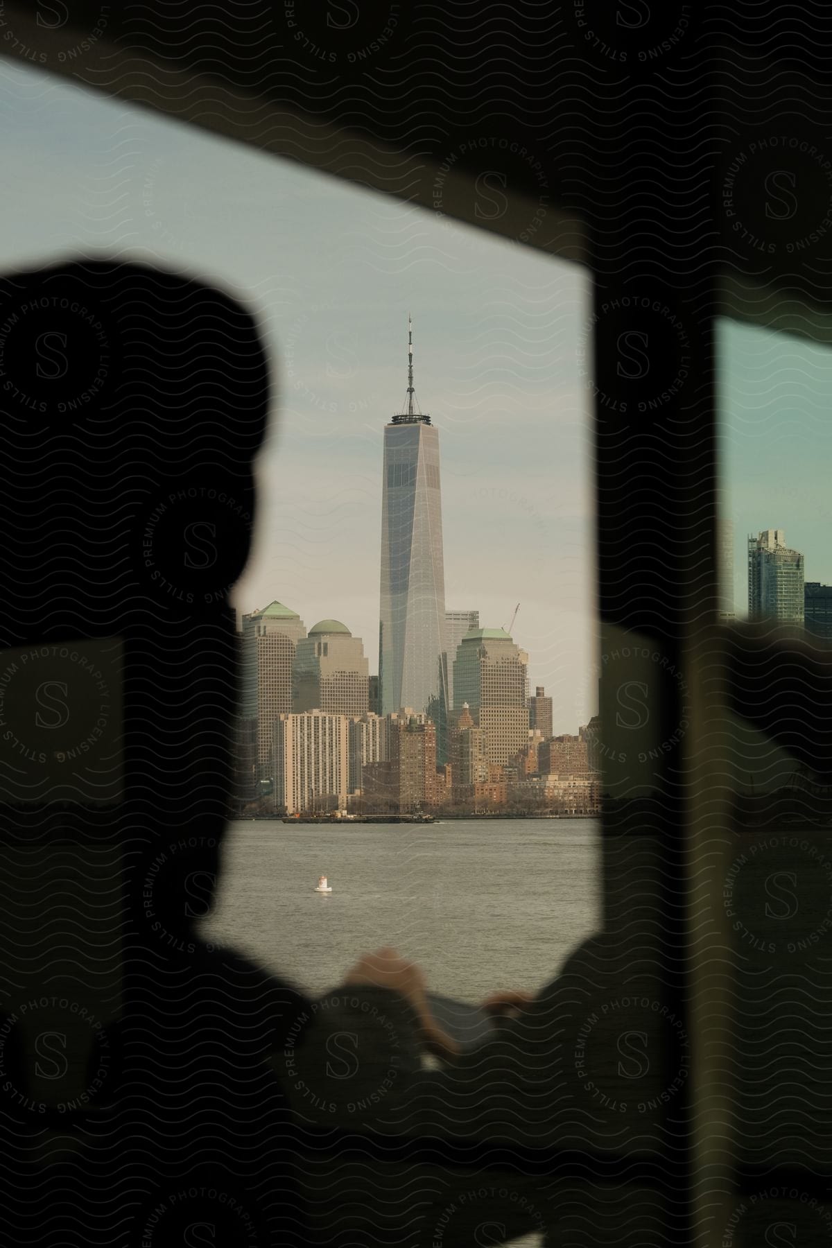 A person on a boat captures pictures of a cityscape with highrise buildings across the water