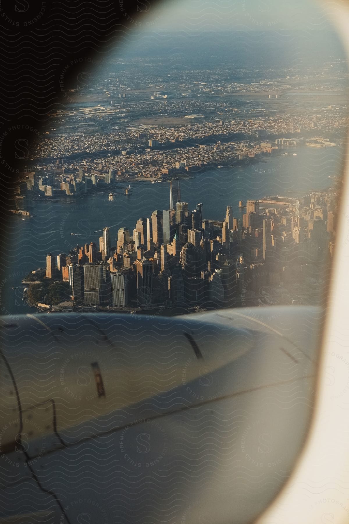 Aerial view of a city with towering skyscrapers seen from an airplane window