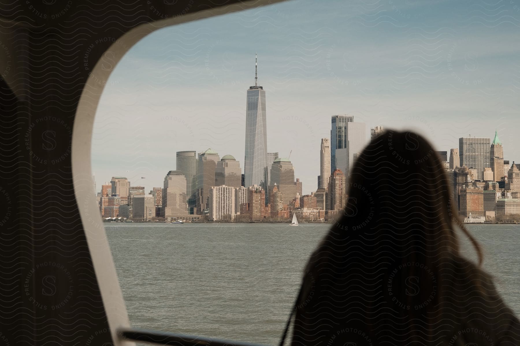 Ocean stretches out shimmering under sunlight with distant vibrant cityscape of towering skyscrapers and highrise buildings