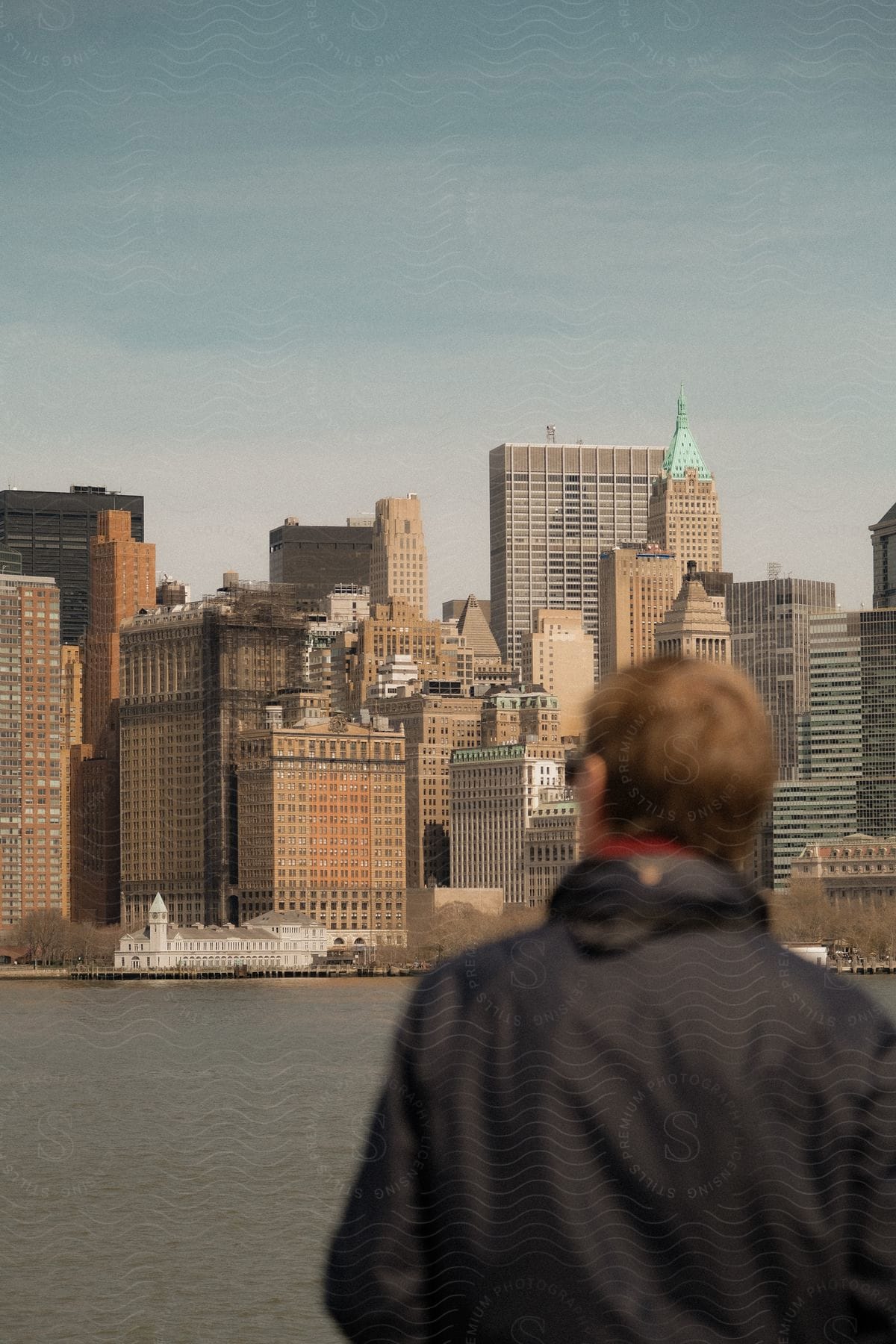 A man looking at a city skyline across a river