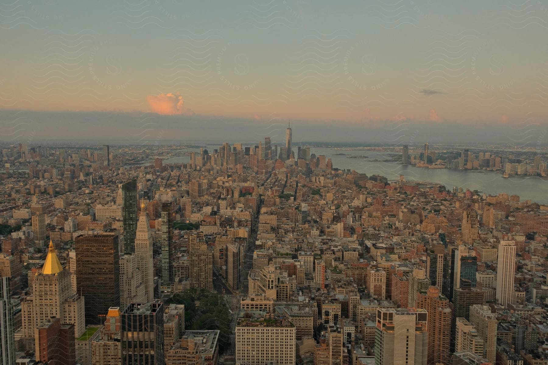 A river flows through a city at dawn with clouds in the sky