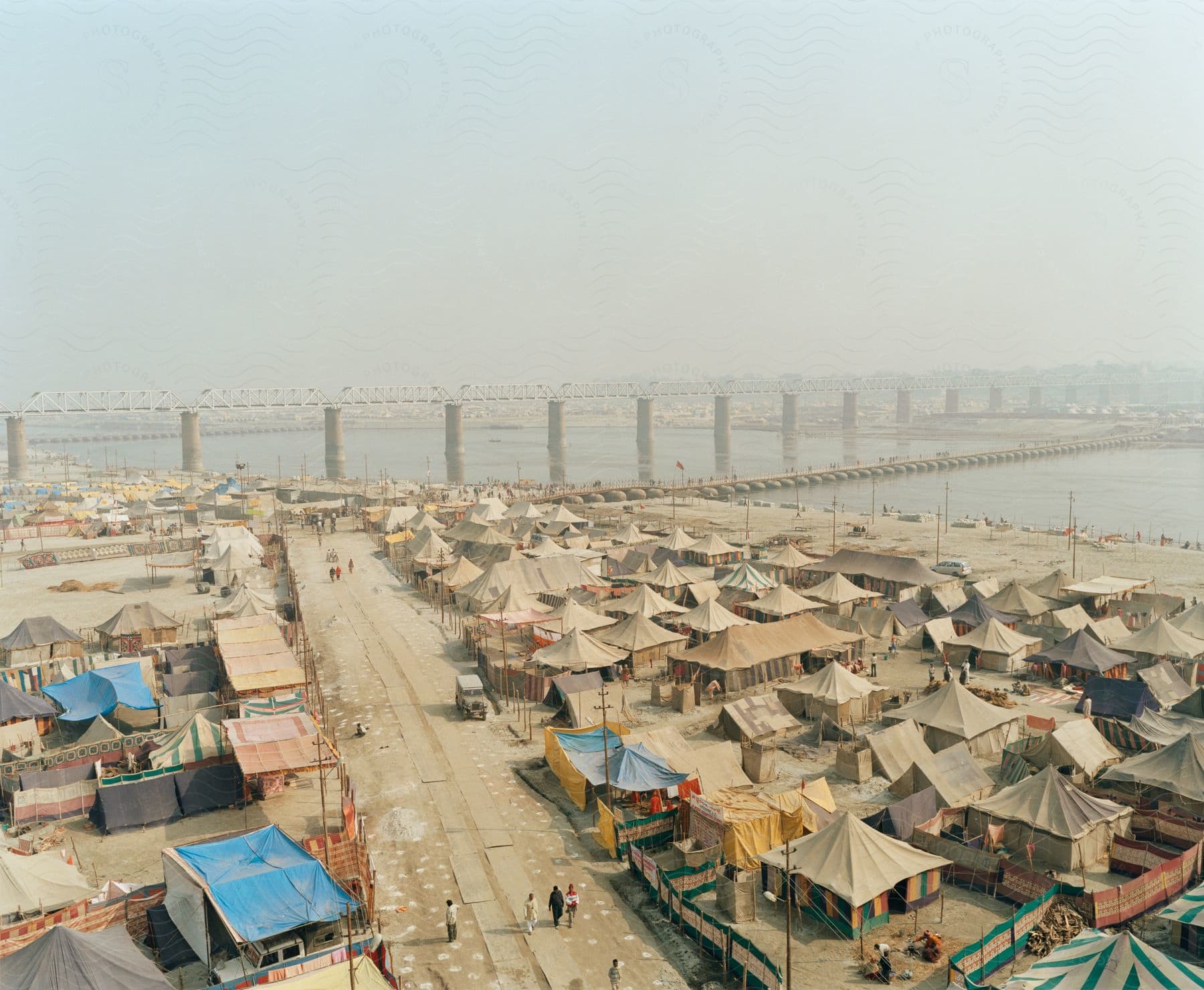 Aerial view of a pilgrims tent city on the banks of a river on a cloudy day