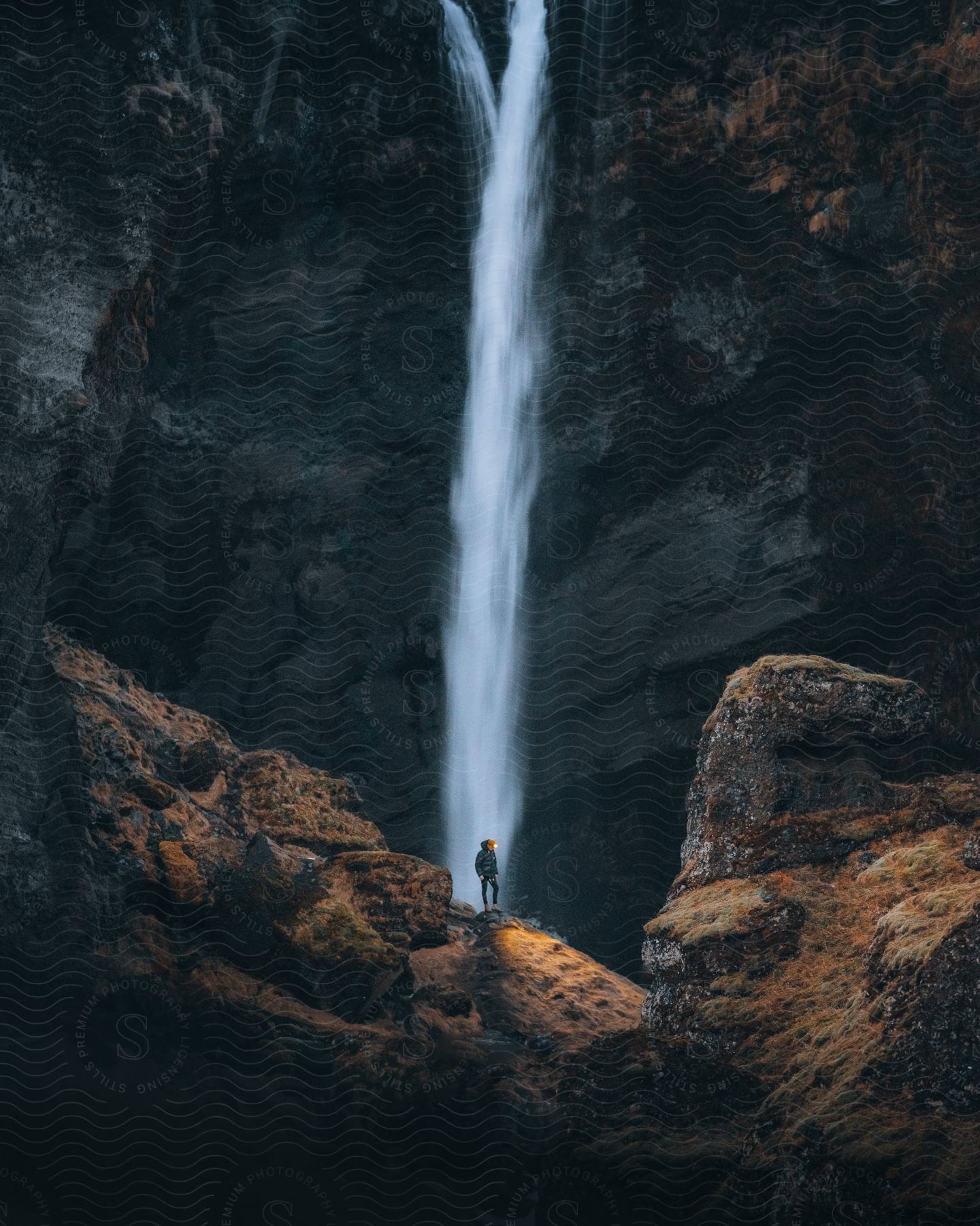 A person gazes at a waterfall in awe of its beauty