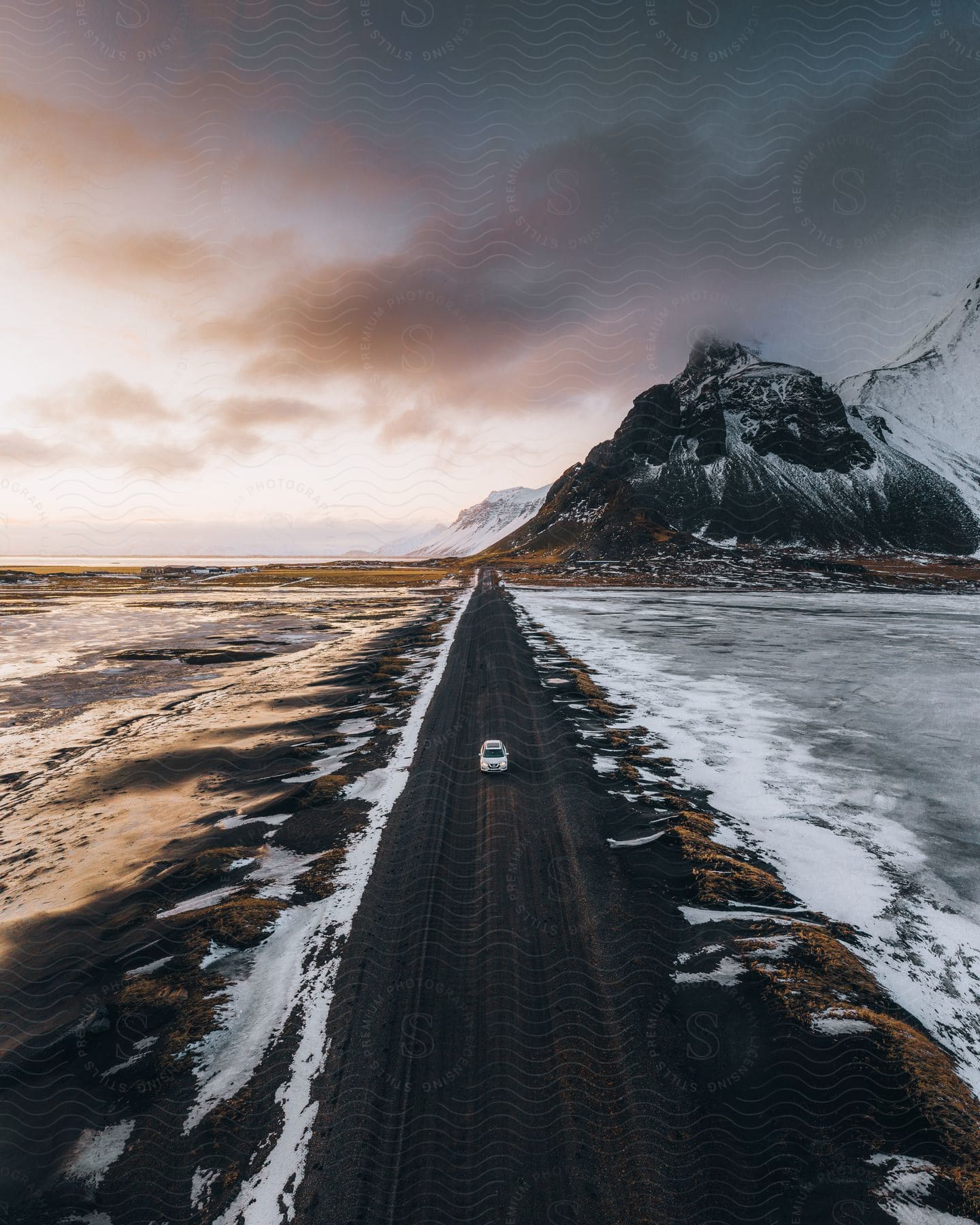 A car drives on a road near the coast captured from above