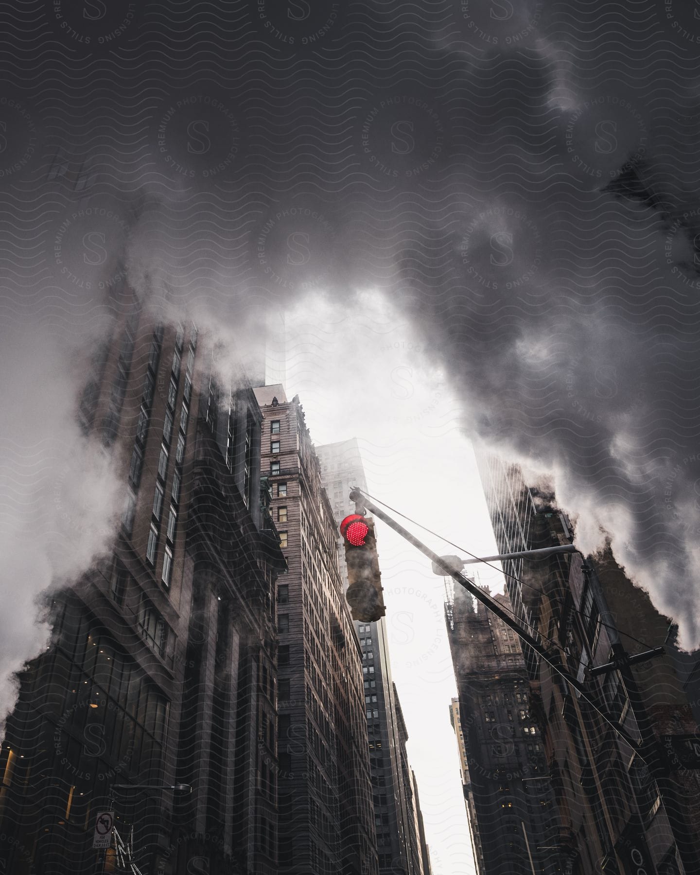 Traffic light on a street of high rises covered by smoke in new york city