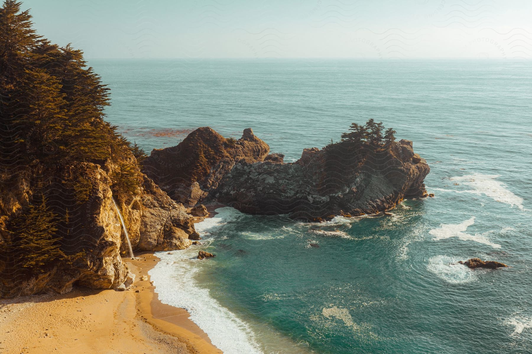 At the beach waves crash against towering cliffs