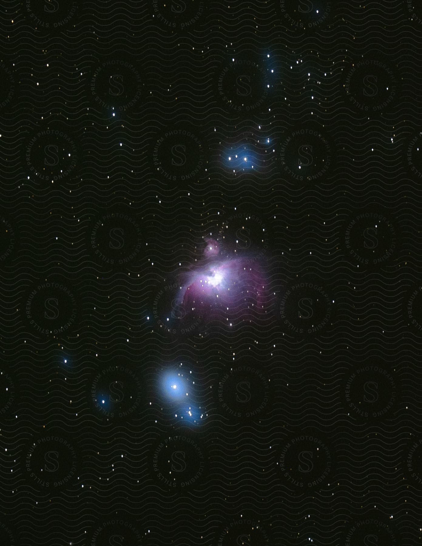 The orion nebula shines brightly in the night sky with stars