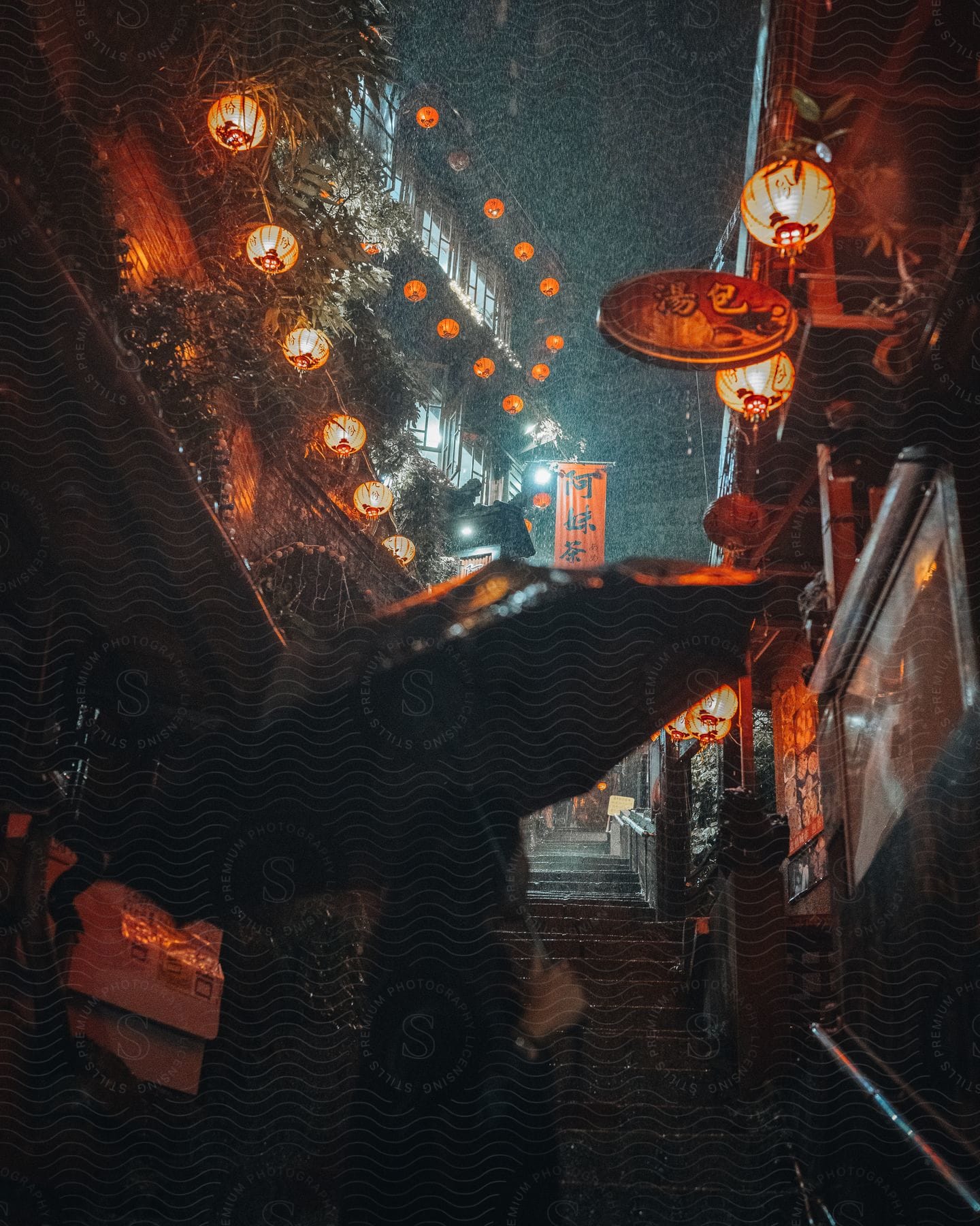 Asian woman in the rain wearing black looking up a staircase on shuqi road taiwan