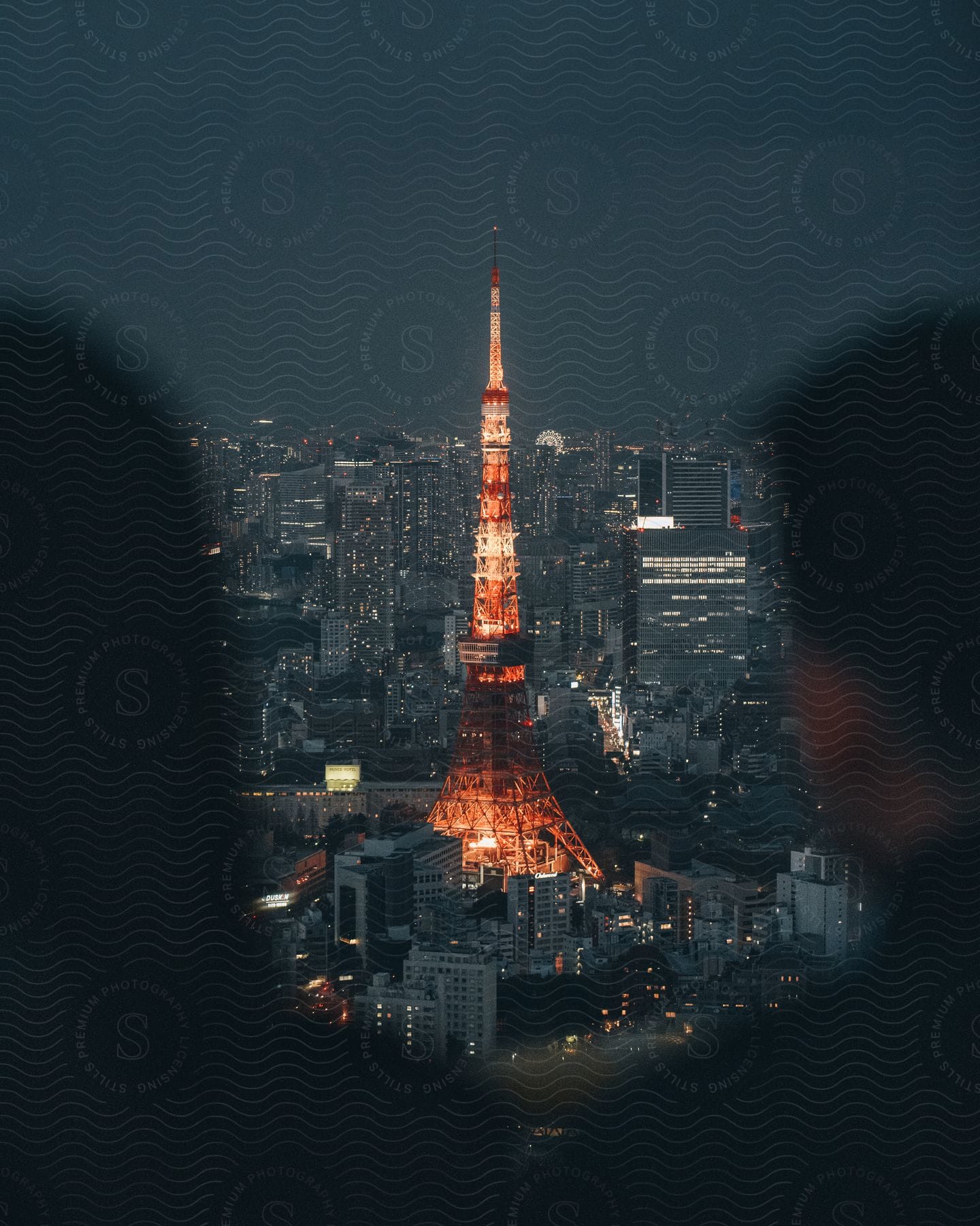 A night scene of a bustling city with a prominent towering structure at its center in tokyo