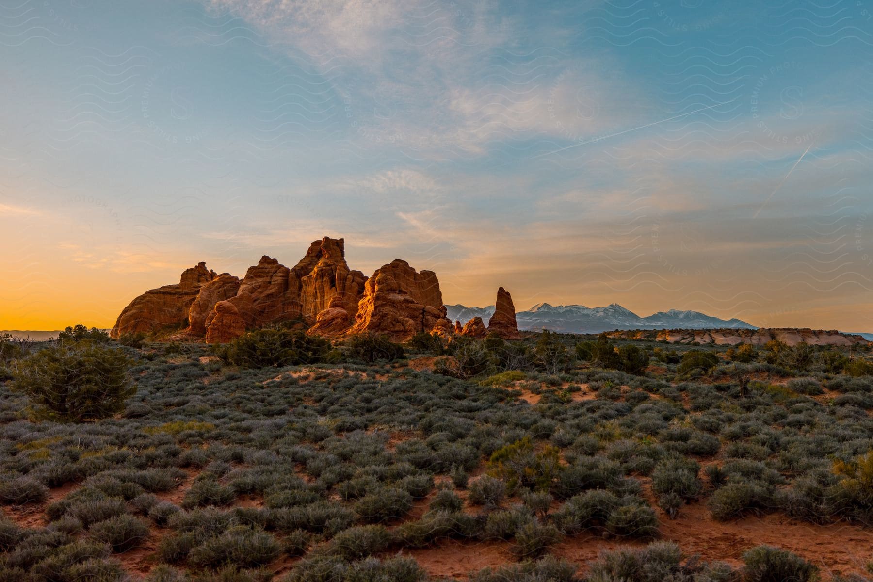 A desert landscape with rock formations and mountains in the distance