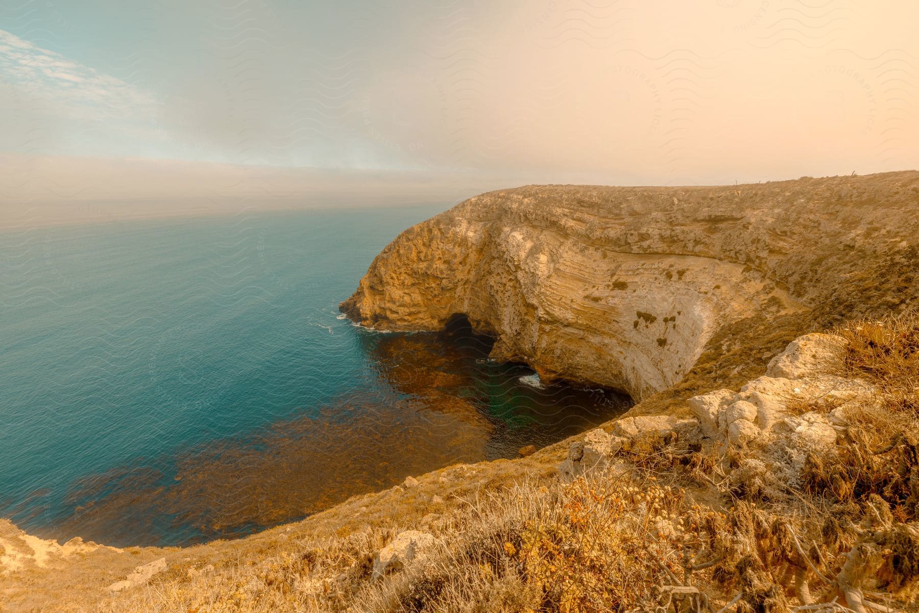 The sun is setting on the coast landscape