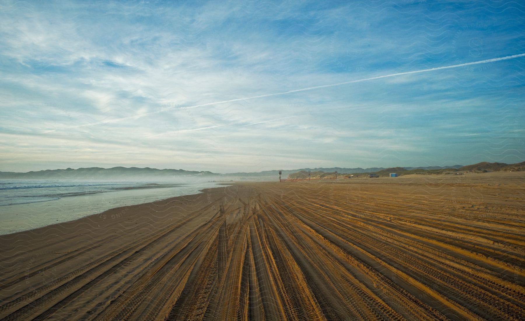 Natural landscape of a beach with tire tracks in the sand