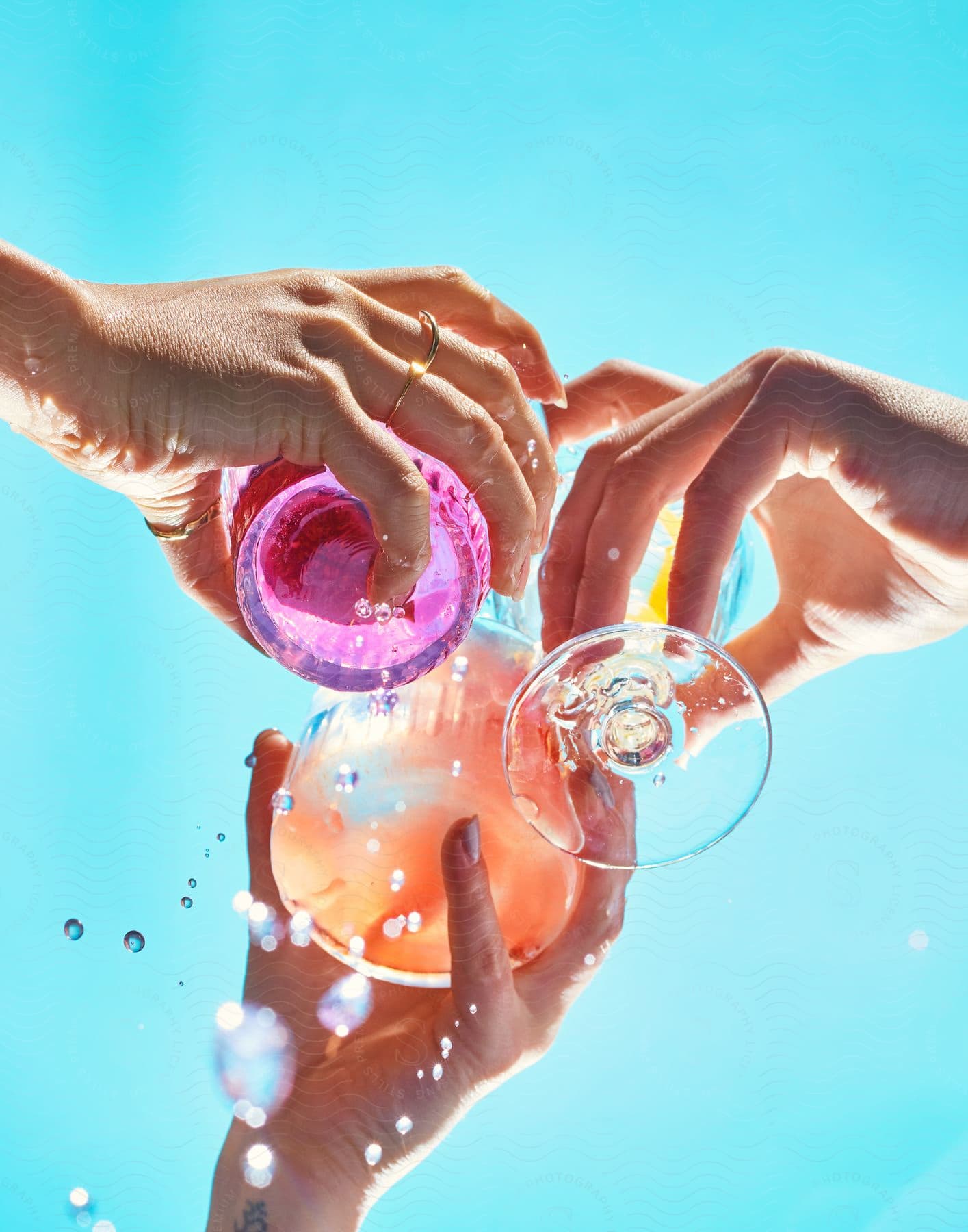 Stock photo of three people holding alcoholic beverages outdoors