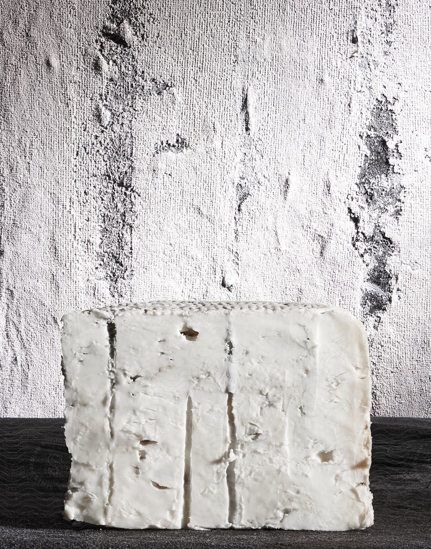 A block of white cheese sitting on a counter