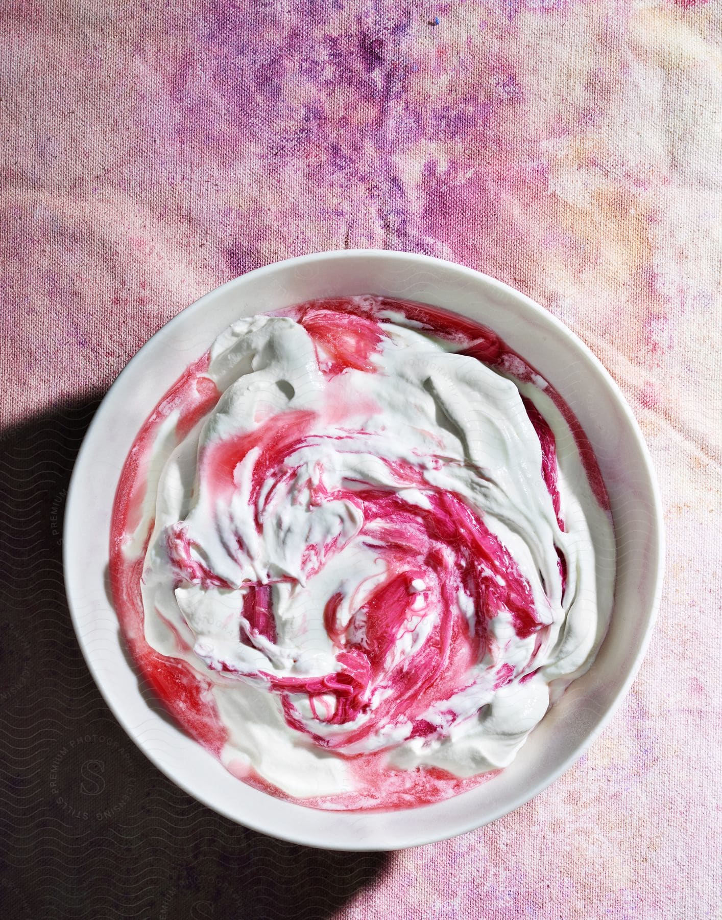 Frozen raspberry and vanilla dessert in a white ramekin on a pastel table cloth