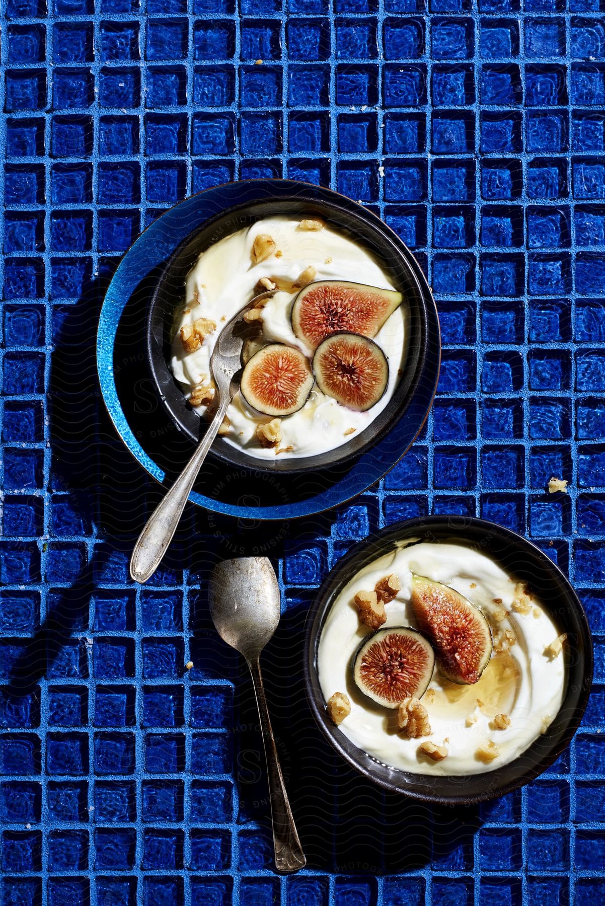 Figs and nuts placed on top of bowls of yogurt
