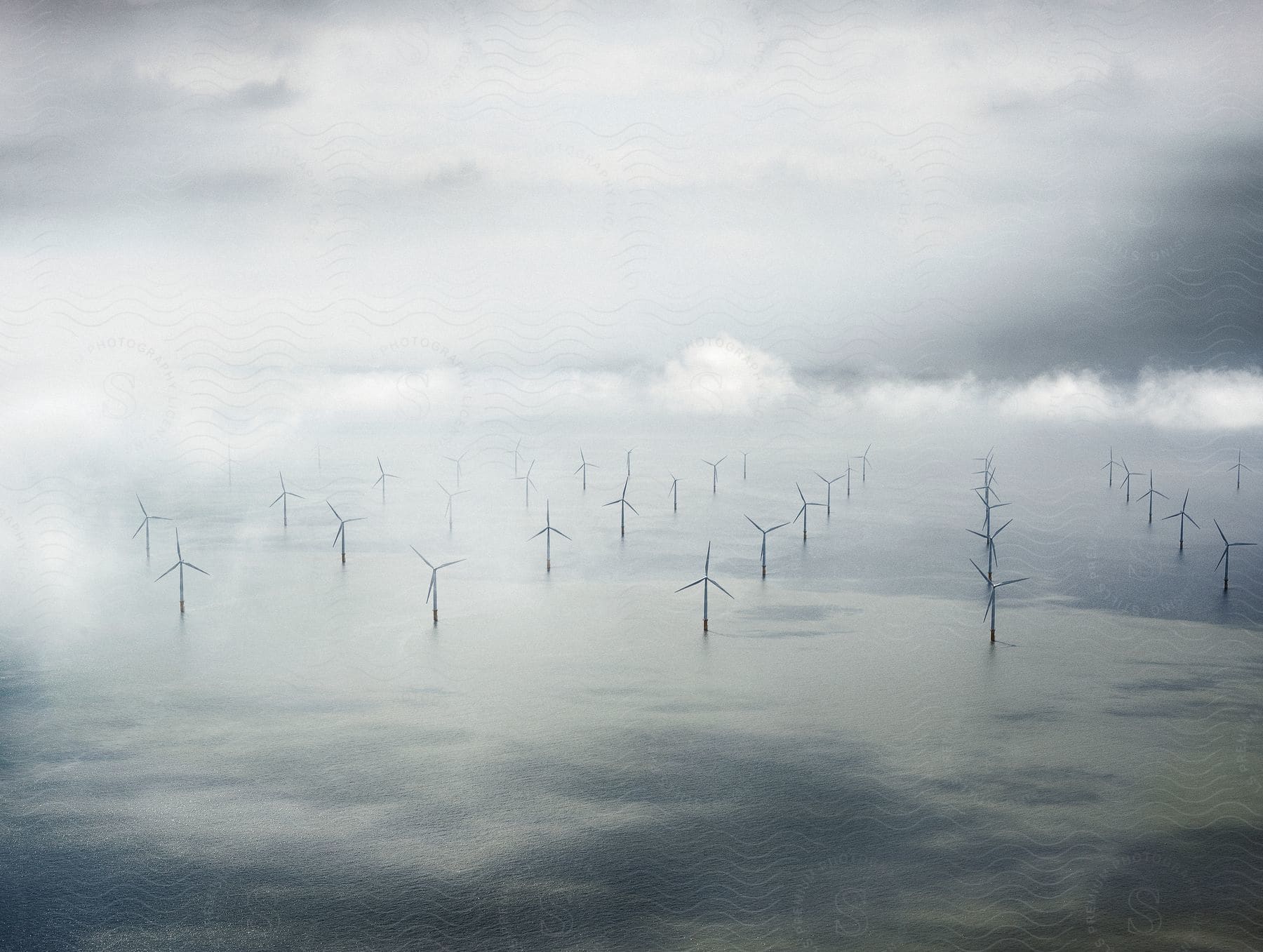 Dozens of windmills are seen in a lake