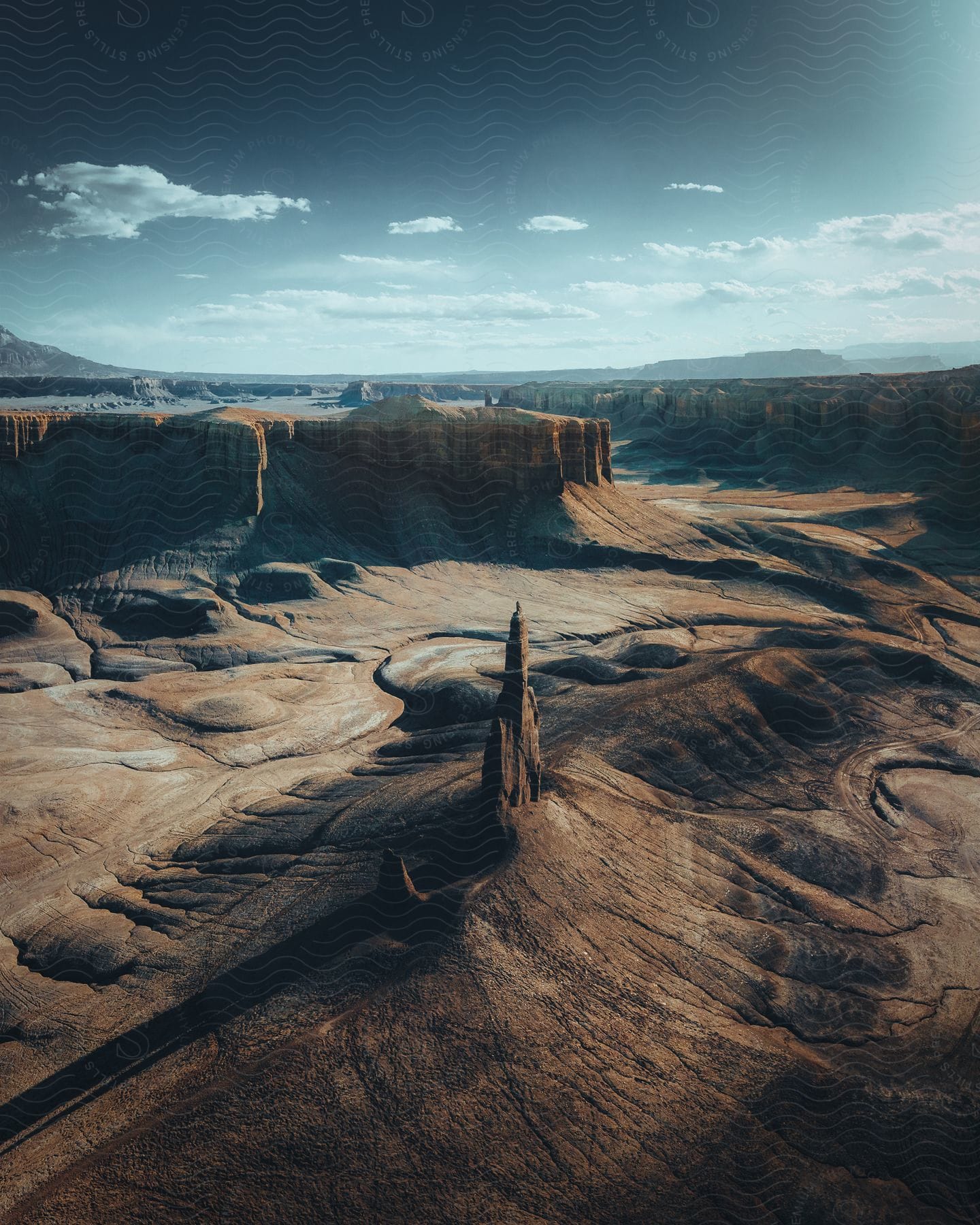 Badland canyons with deep slopes and rock formations under a cloudy sky in utah