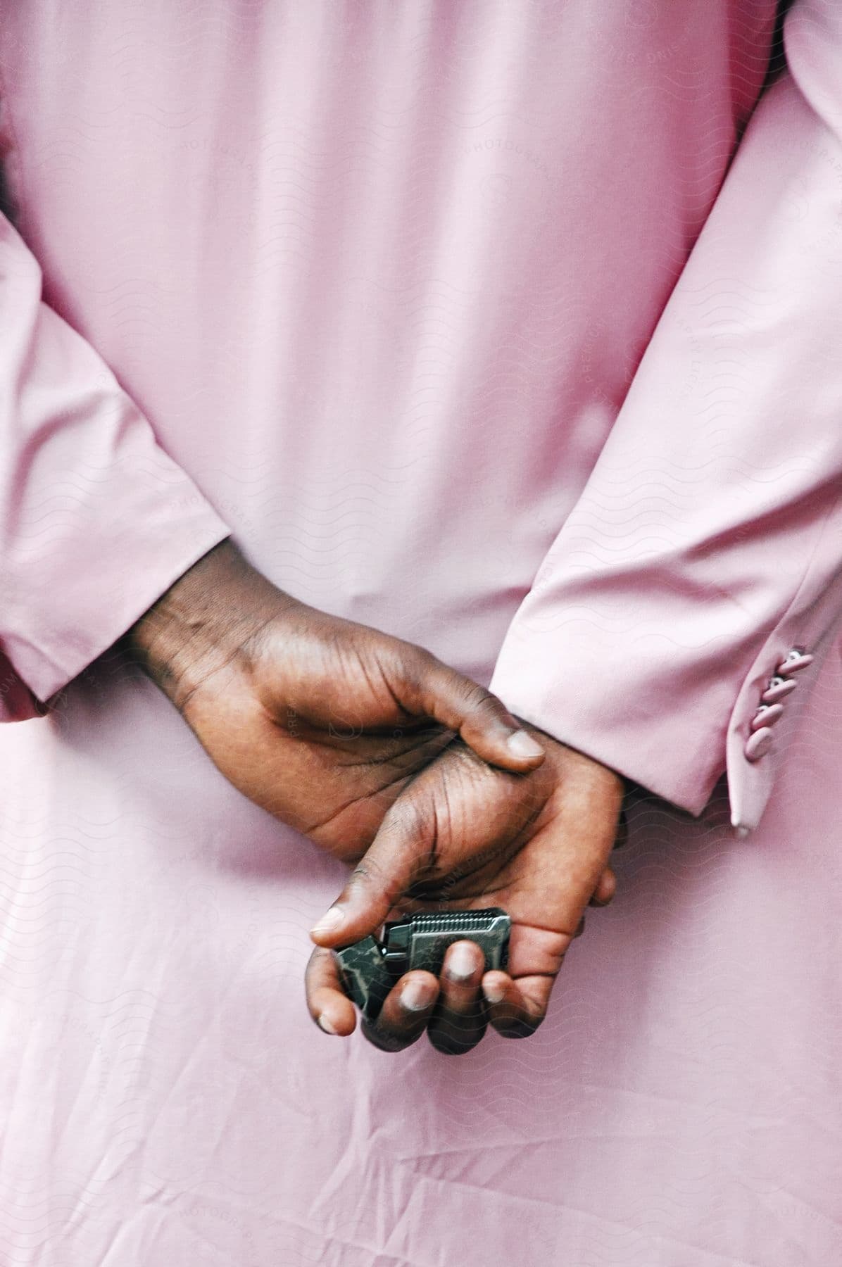 Woman wearing pink overcoat holds lighter in her hand