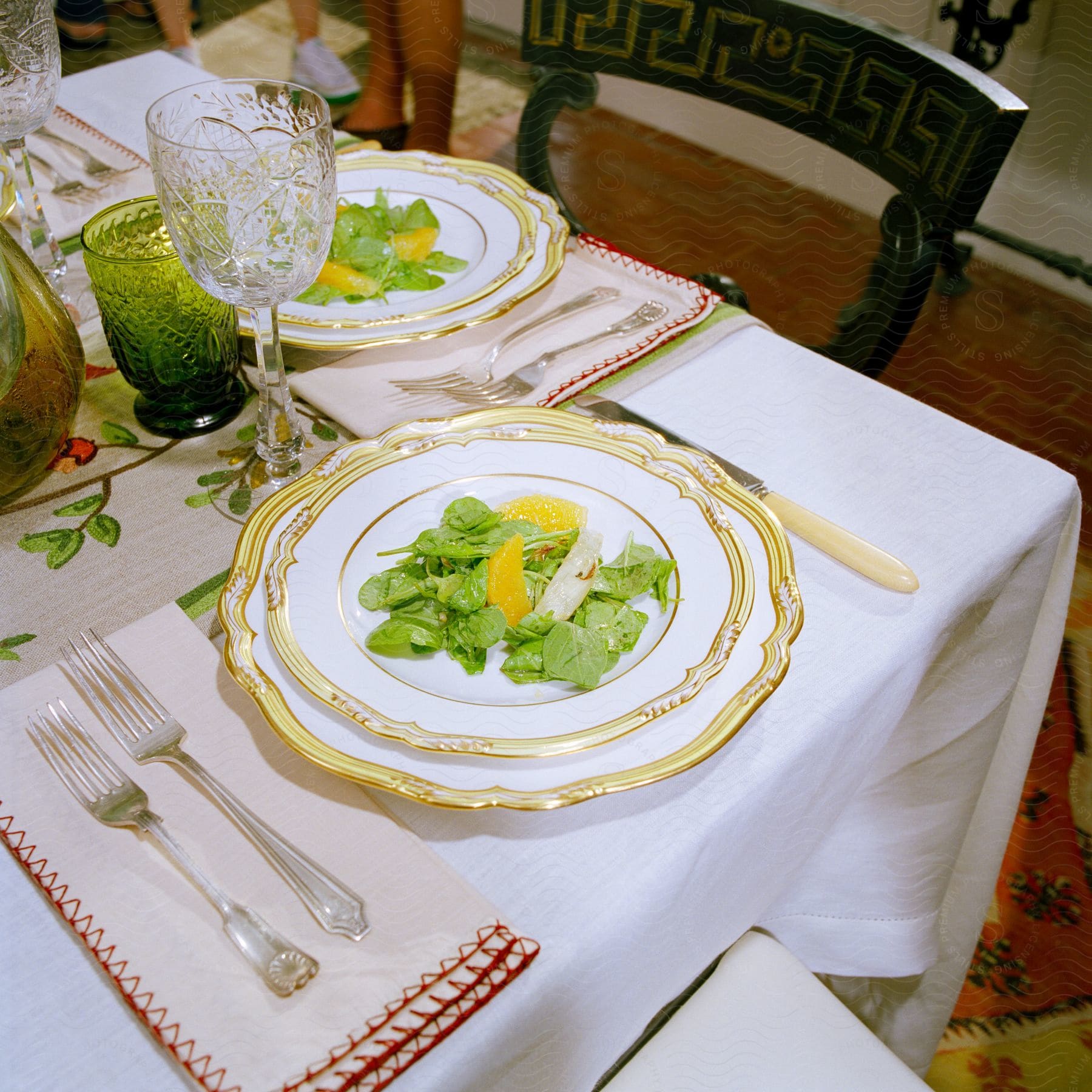 Salads plated on gold rimmed plates on a dinner table