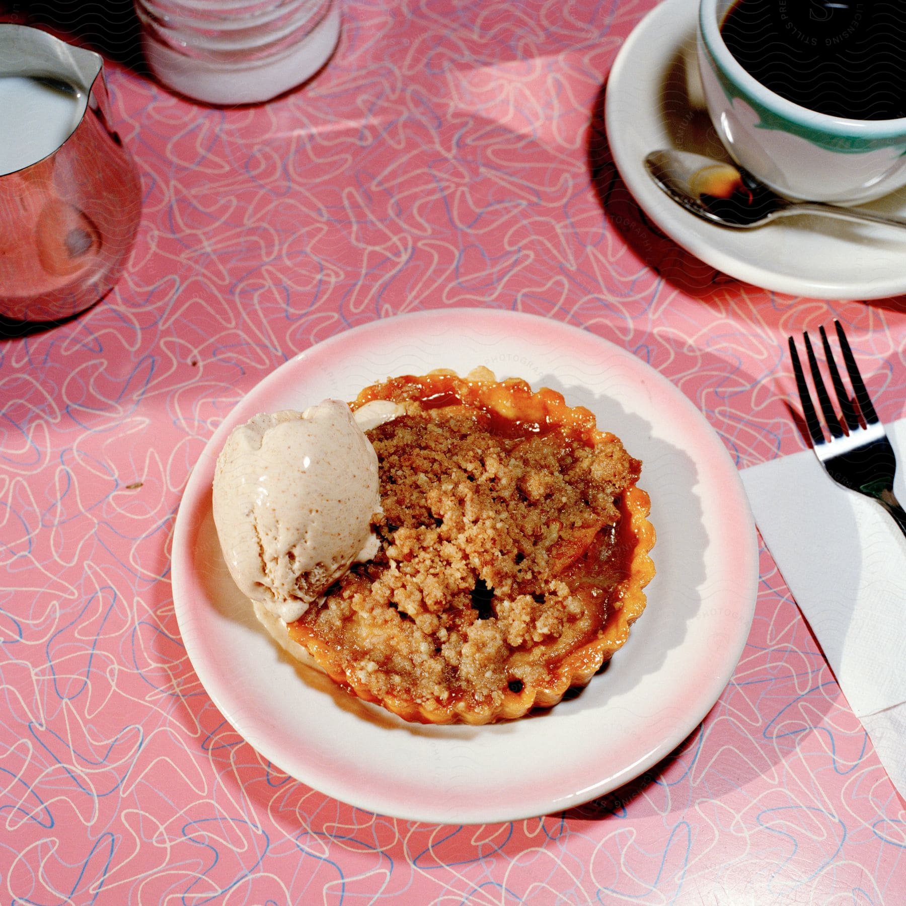 Stock photo of a close up of ice cream and a tart sitting on a vintage pink table