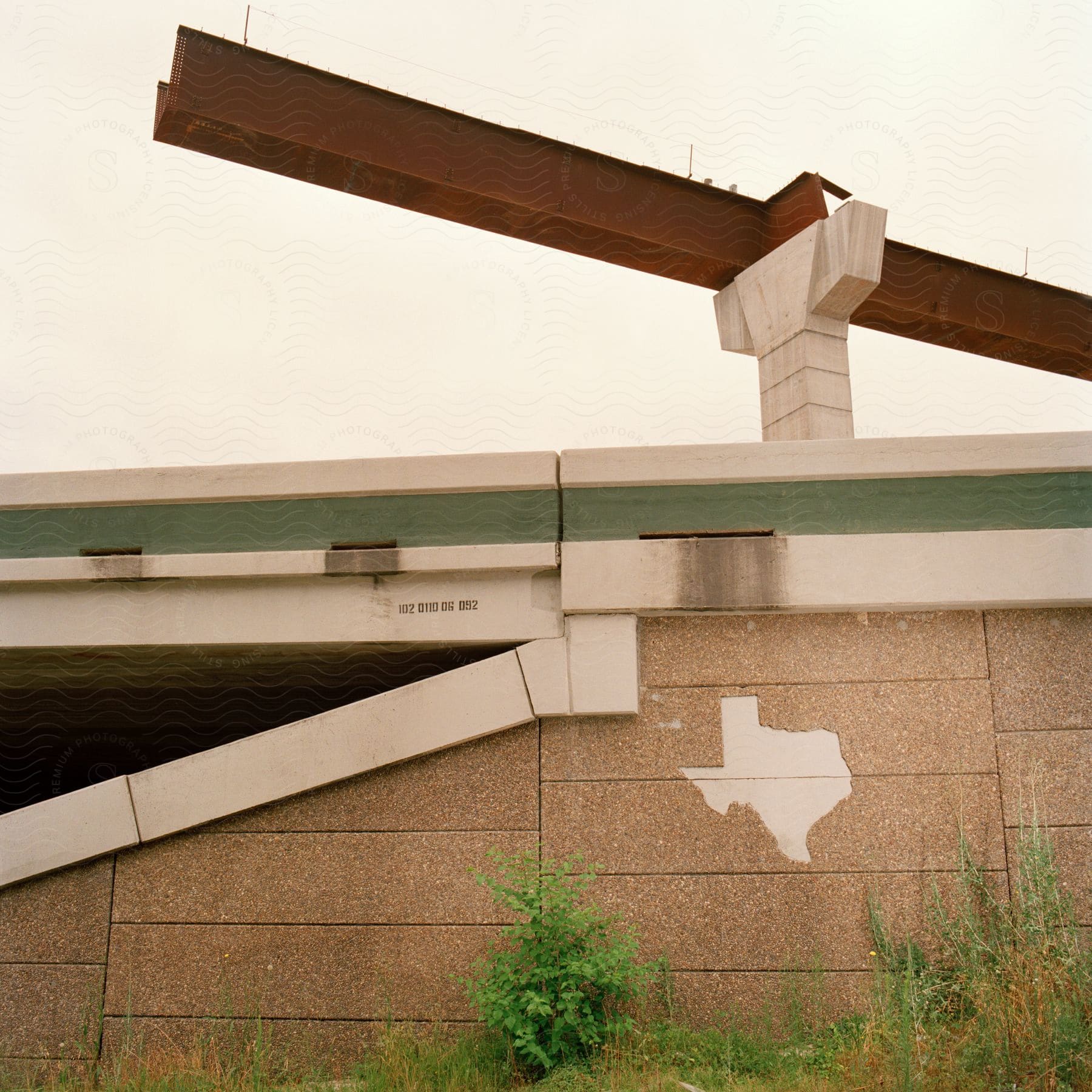An unfinished metal beam atop a highway pillar in texas part of a new overpass over an existing highway bridge