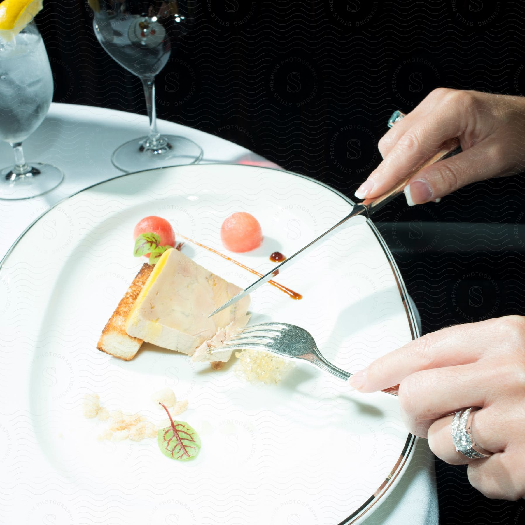 A person cuts into a fish entree at a restaurant